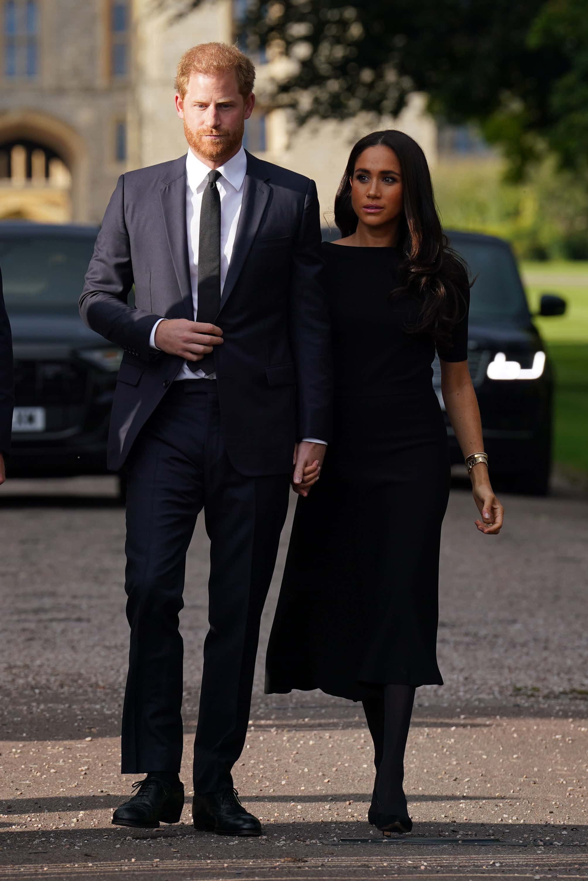 Prince Harry, Duke of Sussex, and Meghan, Duchess of Sussex walk together to meet members of the public on the long Walk at Windsor Castle on September 10, 2022 in Windsor, England. Crowds have gathered and tributes left at the gates of Windsor Castle to Queen Elizabeth II, who died at Balmoral Castle on 8 September, 2022.