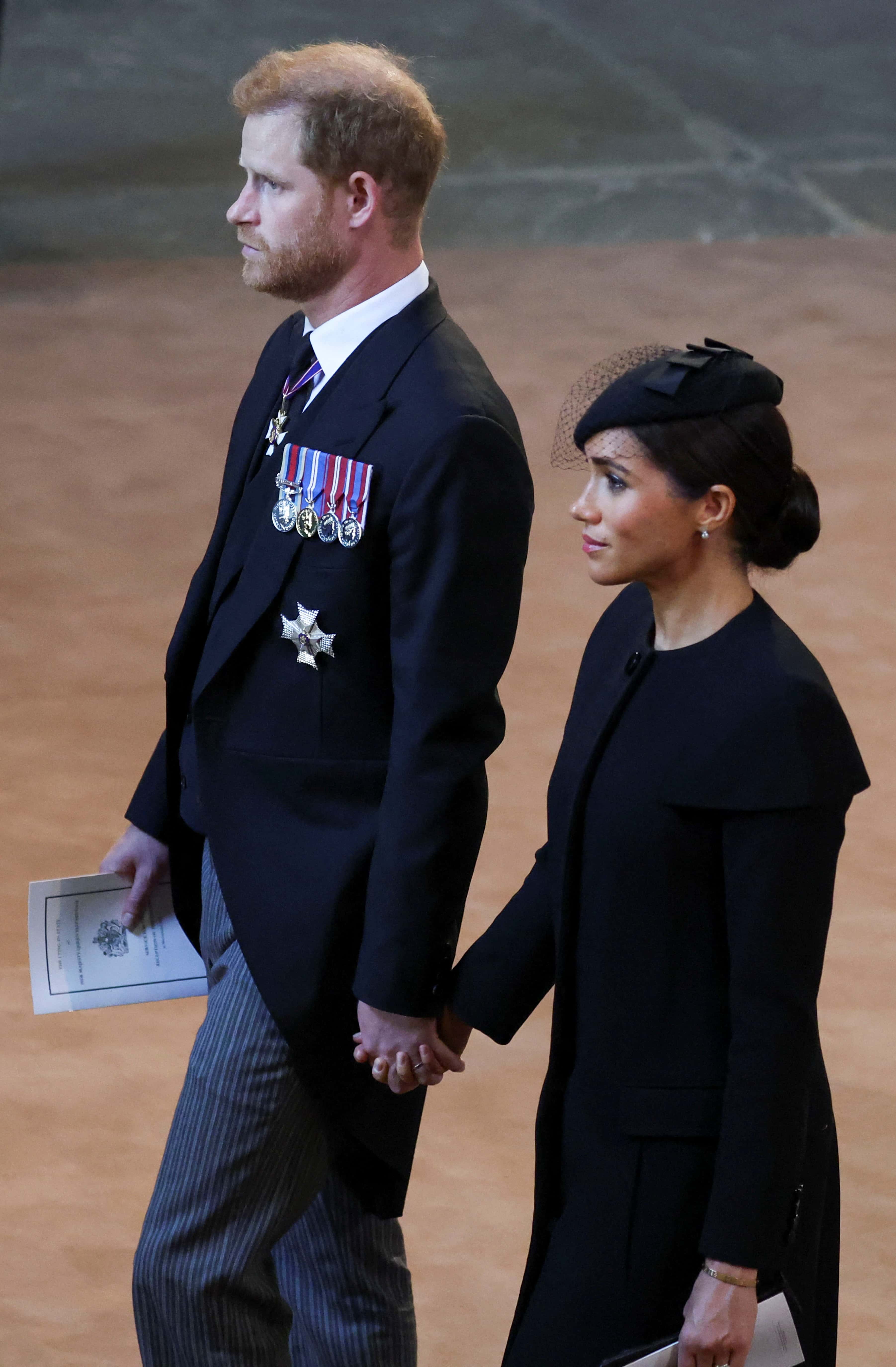 Prince Harry, Duke of Sussex and Meghan, Duchess of Sussex walk as procession with the coffin of Britain's Queen Elizabeth arrives at Westminster Hall from Buckingham Palace for her lying in state, on September 14, 2022 in London, United Kingdom. Queen Elizabeth II's coffin is taken in procession on a Gun Carriage of The King's Troop Royal Horse Artillery from Buckingham Palace to Westminster Hall where she will lay in state until the early morning of her funeral. Queen Elizabeth II died at Balmoral Castle in Scotland on September 8, 2022, and is succeeded by her eldest son, King Charles III.