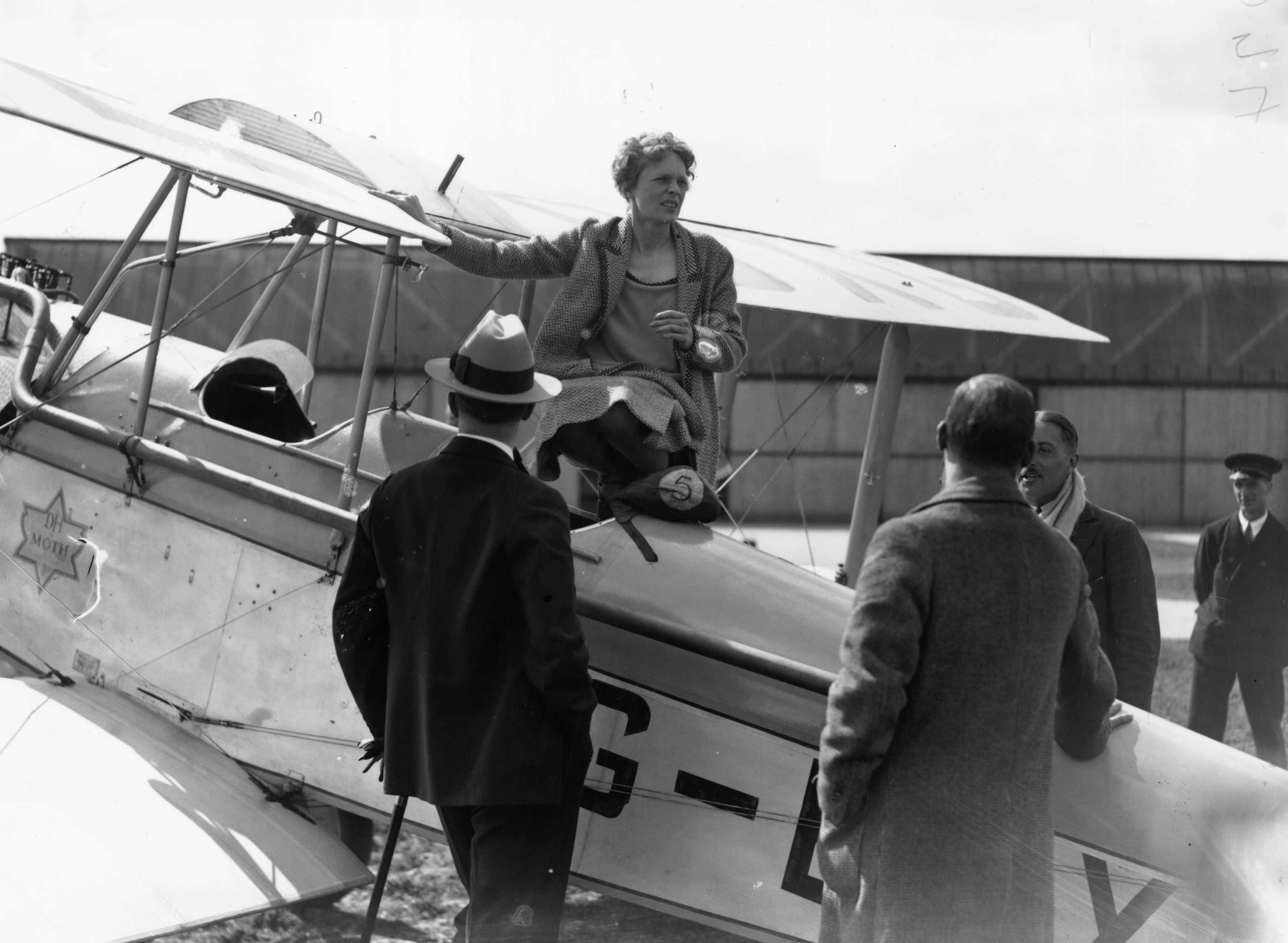 American aviatrix Amelia Earhart (1898 - 1937) talking to friends from the cockpit of her Moth on the day of her trip to Northolt (Getty Images)
