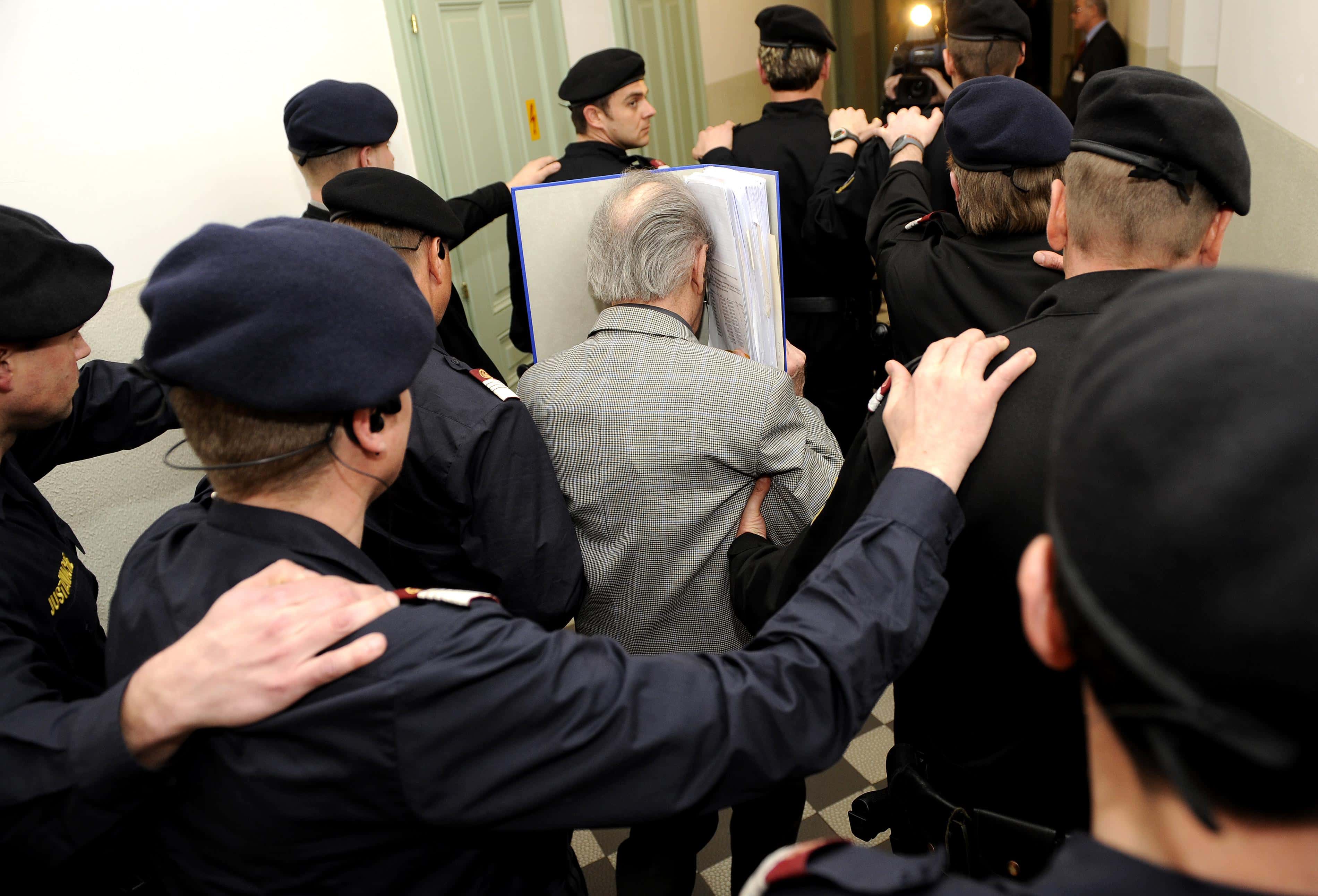 In this handout picture Josef Fritzl (C) covers his face as he arrives at the second day of his trial at the country court of St. Poelten on March 17, 2009 in St. Poelten, Austria. The 73-year-old Austrian is on trial for murder, rape and incest after allegedly imprisoning his daughter in a cellar for 24 years and fathering seven children with her. (Photo Handout by APA via Getty Images)