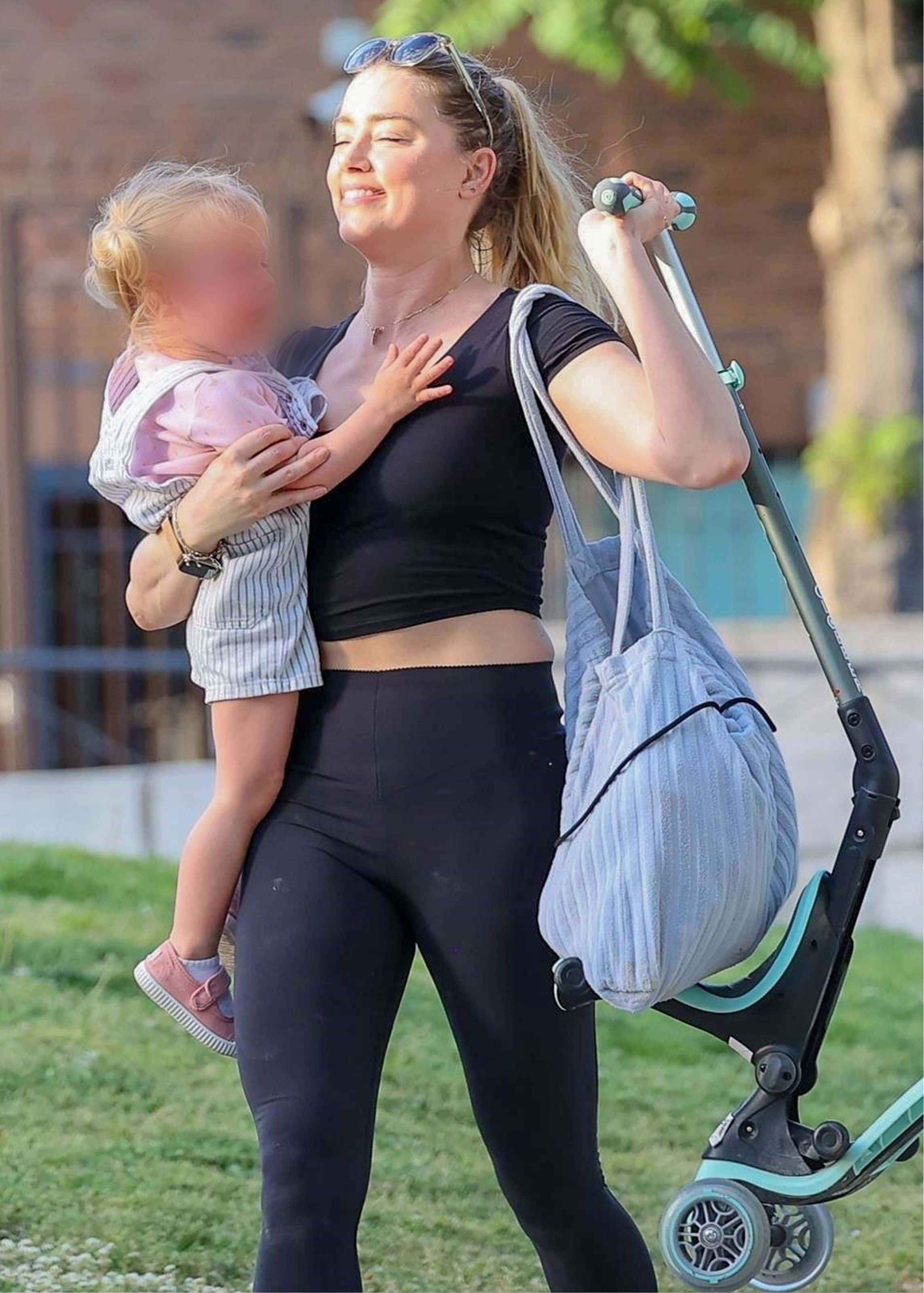 Amber’s mini-me daughter wore a bright pink T-shirt with a pair of matching shoes and blue-and-white striped dungarees. (backgrid)
