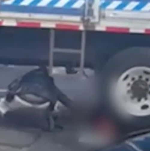 The photo indicates the woman taking up the  purse from the dead body (New York Post screenshot)