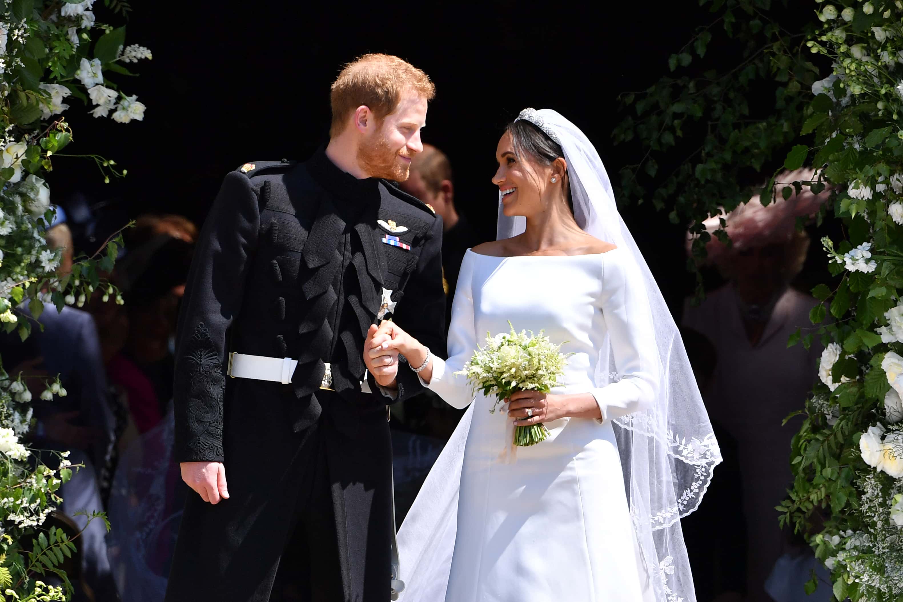 Britain's Prince Harry, Duke of Sussex and his wife Meghan, Duchess of Sussex leave from the West Door of St George's Chapel, Windsor Castle, in Windsor on May 19, 2018 in Windsor, England. (Photo by Ben STANSALL - WPA Pool/Getty Images)