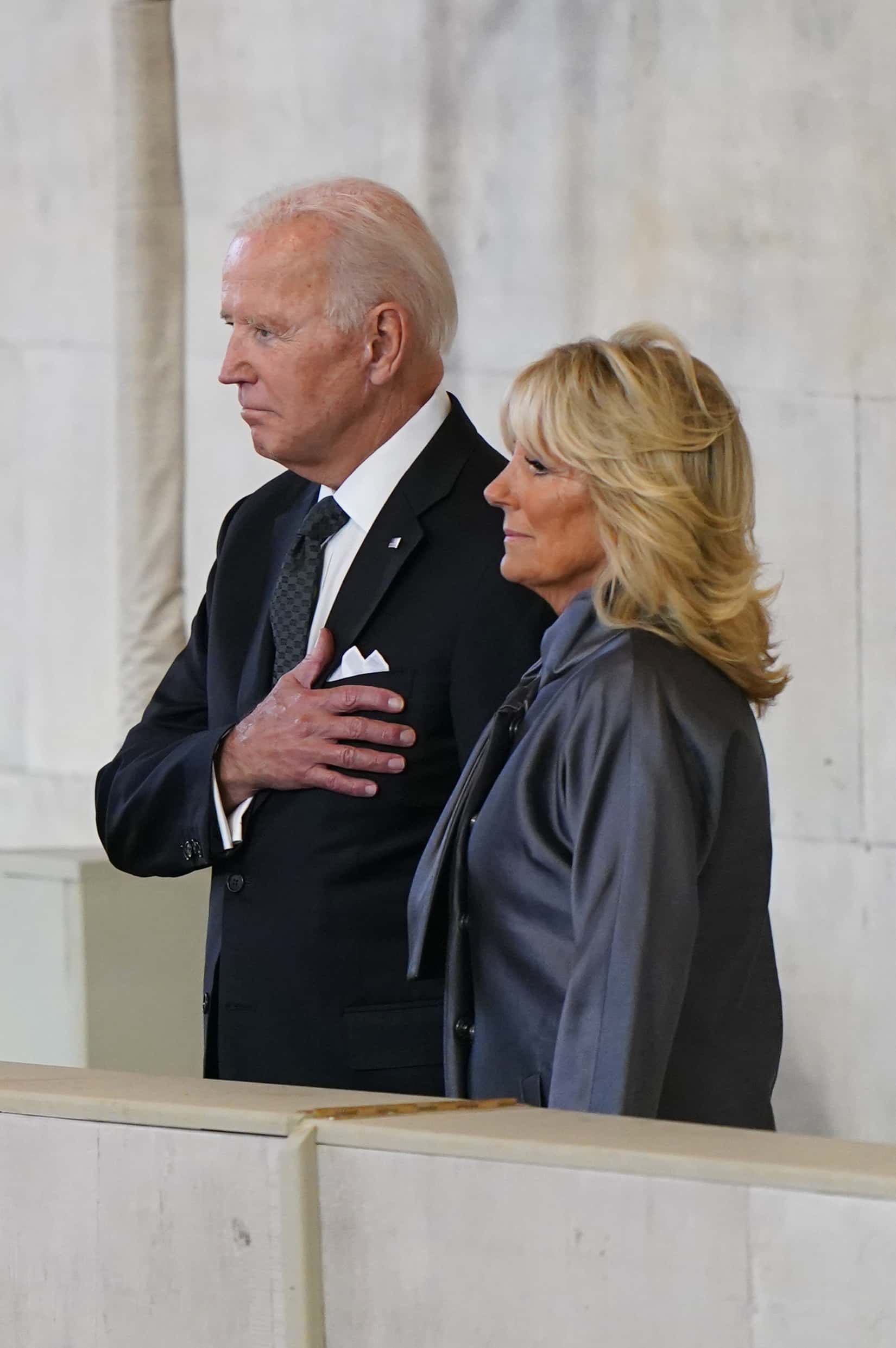 U.S. President Joe Biden gestures next to first lady Jill Biden as they view the coffin of Queen Elizabeth II lying in state at Westminster Hall on September 18, 2022 in London, England. Members of the public are able to pay respects to Her Majesty Queen Elizabeth II for 23 hours a day from 17:00 on September 18, 2022 until 06:30 on September 19, 2022.  Queen Elizabeth II died at Balmoral Castle in Scotland on September 8, 2022, and is succeeded by her eldest son, King Charles III.