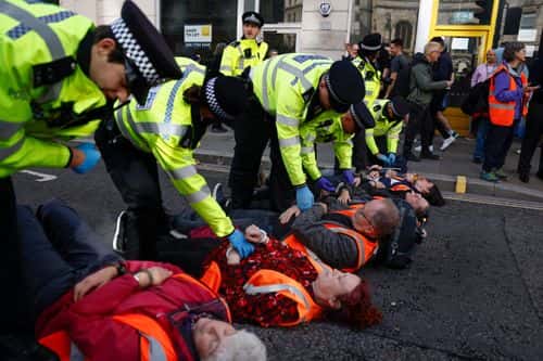 'Just Stop Oil' protesters are arrested after they blocked the road at the junction of Cannon St and Queen Victoria St on October 27, 2022 in London, England. The environmental activist group has staged a series of guerrilla protests in London in recent weeks. (Photo by Jeff J Mitchell/Getty Images)
