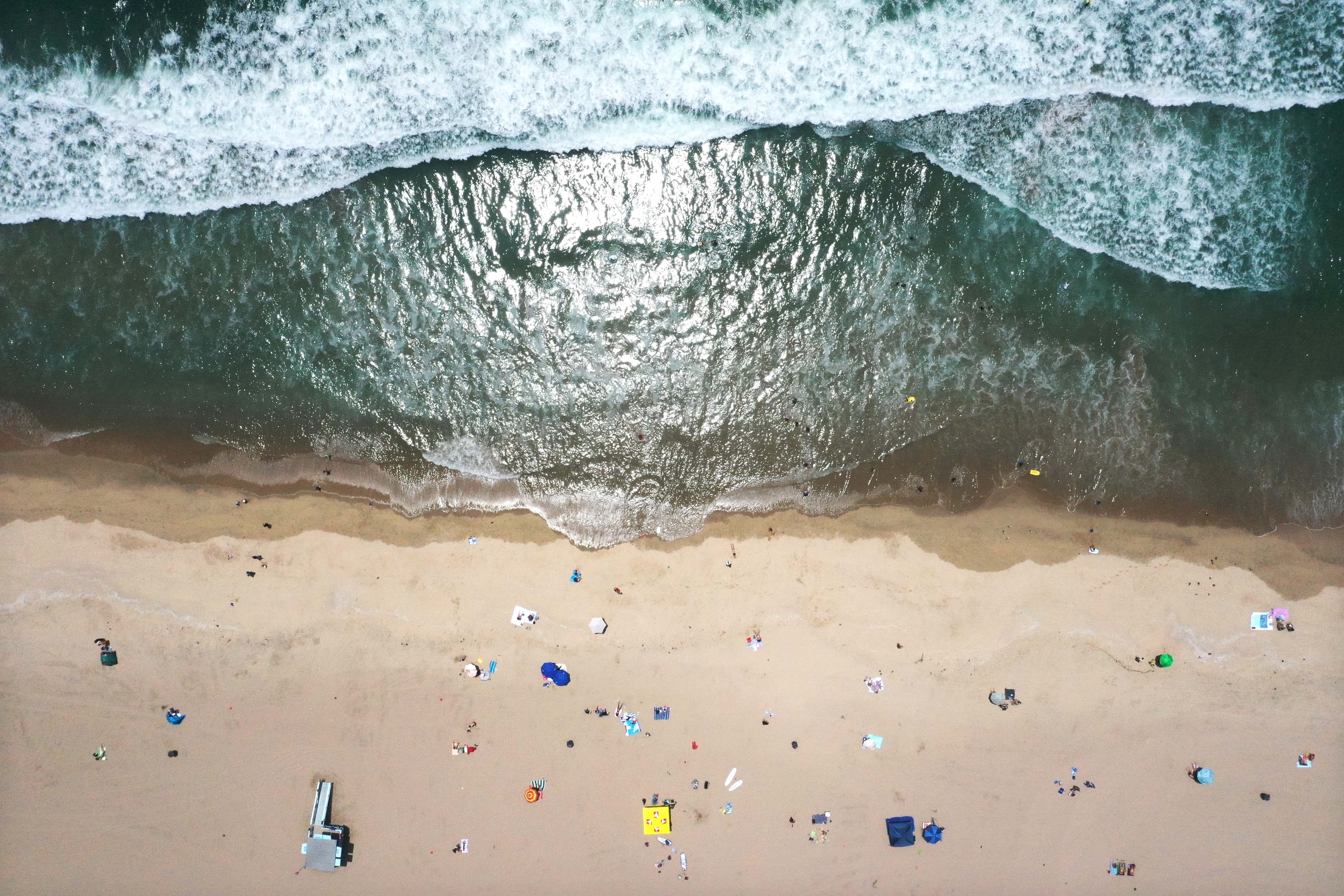 In an aerial view, people gather in the sand at Bruce's Beach on June 29, 2022 in Manhattan Beach, California. The beachfront property was once a seaside resort owned by Charles and Willa Bruce, a Black couple, which catered to African Americans. Amid the Jim Crow era, the city claimed the property in 1924 through eminent domain while vastly underpaying the couple for the land. The Los Angeles County Board of Supervisors has approved the plan to return ownership of the prime beachfront property to the descendants of Willa and Charles Bruce.