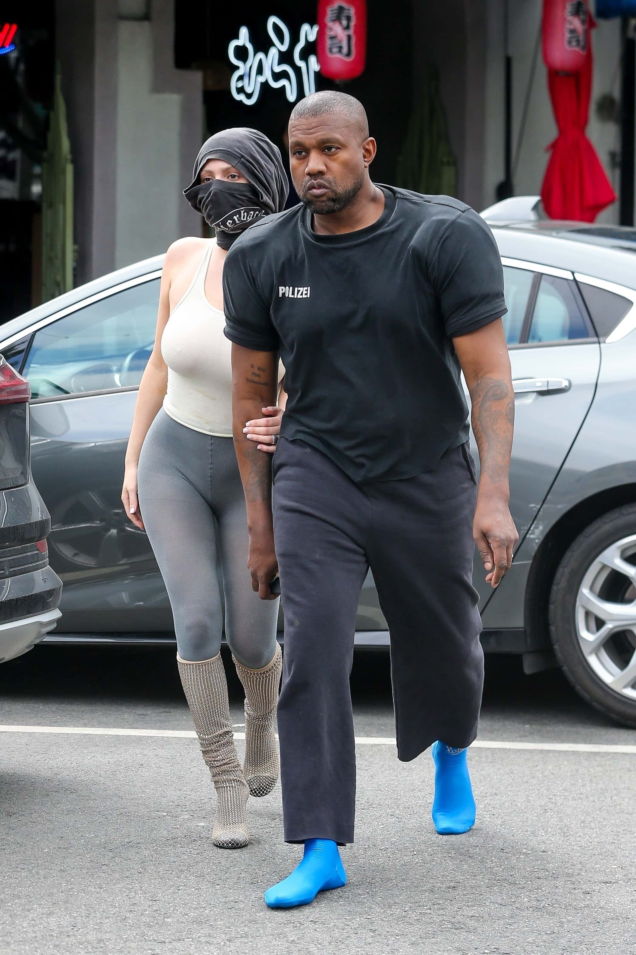 The Donda rapper, 45, and his new muse, 27, stopped by Jeni's Splendid Ice Creams, with Kanye rocking a black t-shirt with large football uniform-style shoulder pads (Backgrid)