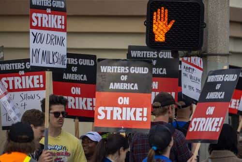 People picket outside of Paramount Pictures studios during the Hollywood writers strike on May 4, 2023 in Los Angeles, California. Scripted TV series, late-night talk shows, film and streaming productions are being interrupted by the Writers Guild of America (WGA) strike. In 2007 and 2008, a WGA strike shut down Hollywood productions for 100 days, costing the local economy between $2 billion and $3 billion.