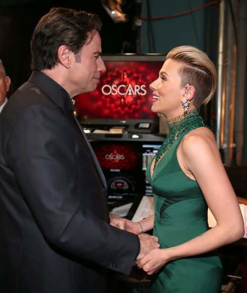 Actors John Travolta and Scarlett Johansson embrace backstage during the 87th Annual Academy Awards at Dolby Theatre on February 22, 2015 in Hollywood, California.