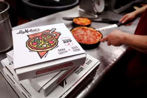 A worker prepares a Chicago-style deep dish pizza at a Lou Malnati's restaurant on March 31, 2022 in Chicago, Illinois. Restaurants, like the family-owned Lou Malnati's, have been hit by rising commodities prices such as wheat, which hit a record high after the start of the war in Ukraine.