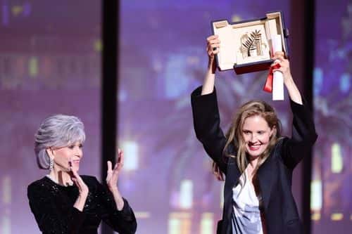 Justine Triet (R) receives The Palme D'Or Award for 'Anatomy of a Fall' from Jane Fonda (L) during the closing ceremony during the 76th annual Cannes film festival at Palais des Festivals on May 27, 2023 in Cannes, France.
