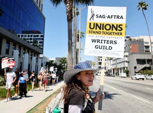 SAG-AFTRA member Christine Robert pickets in solidarity with striking WGA (Writers Guild of America) workers outside Netflix offices on July 12, 2023 in Los Angeles, California. Members of SAG-AFTRA, which represents actors and other media professionals, may go on strike by 11:59 p.m. today which could shut down Hollywood productions completely with the writers in the third month of their strike against Hollywood studios.