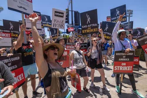 Members of the Hollywood actors SAG-AFTRA union walk a picket line with screenwriters outside of Paramount Studios on the first day of the actors' strike on July 14, 2023 in Los Angeles, California. Members of SAG-AFTRA, Hollywood’s largest union which represents actors and other media professionals, joined striking WGA (Writers Guild of America) workers in the first joint walkout against the studios since 1960. The strike could shut down Hollywood productions completely with writers in the third month of their strike against the Hollywood studios.