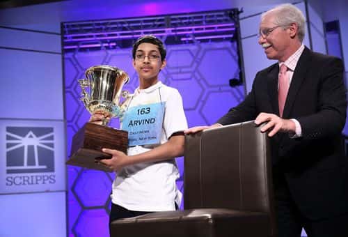 Arvind Mahankali of Bayside Hills, New York holds his trophy as president of the E.W. Scripps Company Rich Boehne pulls a chair for him to sit on after the finals of the 2013 Scripps National Spelling Bee May 30, 2013 at Gaylord National Resort and Convention Center in National Harbor, Maryland. Mahankali has won the championship of the annual spelling contest after he correctly spelled the word 