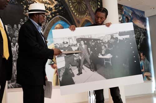Mustafa Hassan, 84, an associate of Malcolm X, points to himself in a picture following the assassination of Malcolm X during a news conference with civil rights attorney Ben Crump and Malcolm X's daughter IIyasah Shabazz on July 25, 2023 in New York City. They allege more information has been discovered which they say points to efforts by the FBI to cover up a conspiracy to murder Malcolm X. Crump and his team said they were unveiling the information, including a new witness speaking for the first time, to show negligence or a possible cover up in the investigation of the famed civil rights leader. Mr. Hassan was at the scene of the assassination but was never interviewed by police. He allegedly heard police ask if a suspected gunman was 