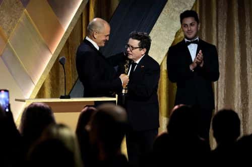 (L-R) Woody Harrelson congratulates Michael J. Fox, winner of the Jean Hersholt Humanitarian Award, onstage during the Academy of Motion Picture Arts and Sciences 13th Governors Awards at Fairmont Century Plaza on November 19, 2022 in Los Angeles, California.