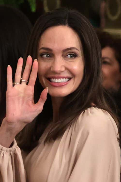 Actress Angelina Jolie waves during an event to mark the reauthorization of the Violence Against Women Act at the East Room of the White House on March 16, 2022 in Washington, DC. President Joe Biden, who helped write the original piece of the legislation in 1994 when he was a senator on Capitol Hill, presided over the event.
