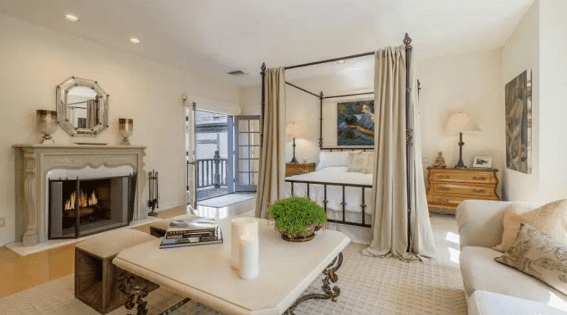 The owner's suite has vaulted and beamed ceilings, dual bathrooms, a refreshment area, a fireplace and a wrap-around terrace(Realtor.com)