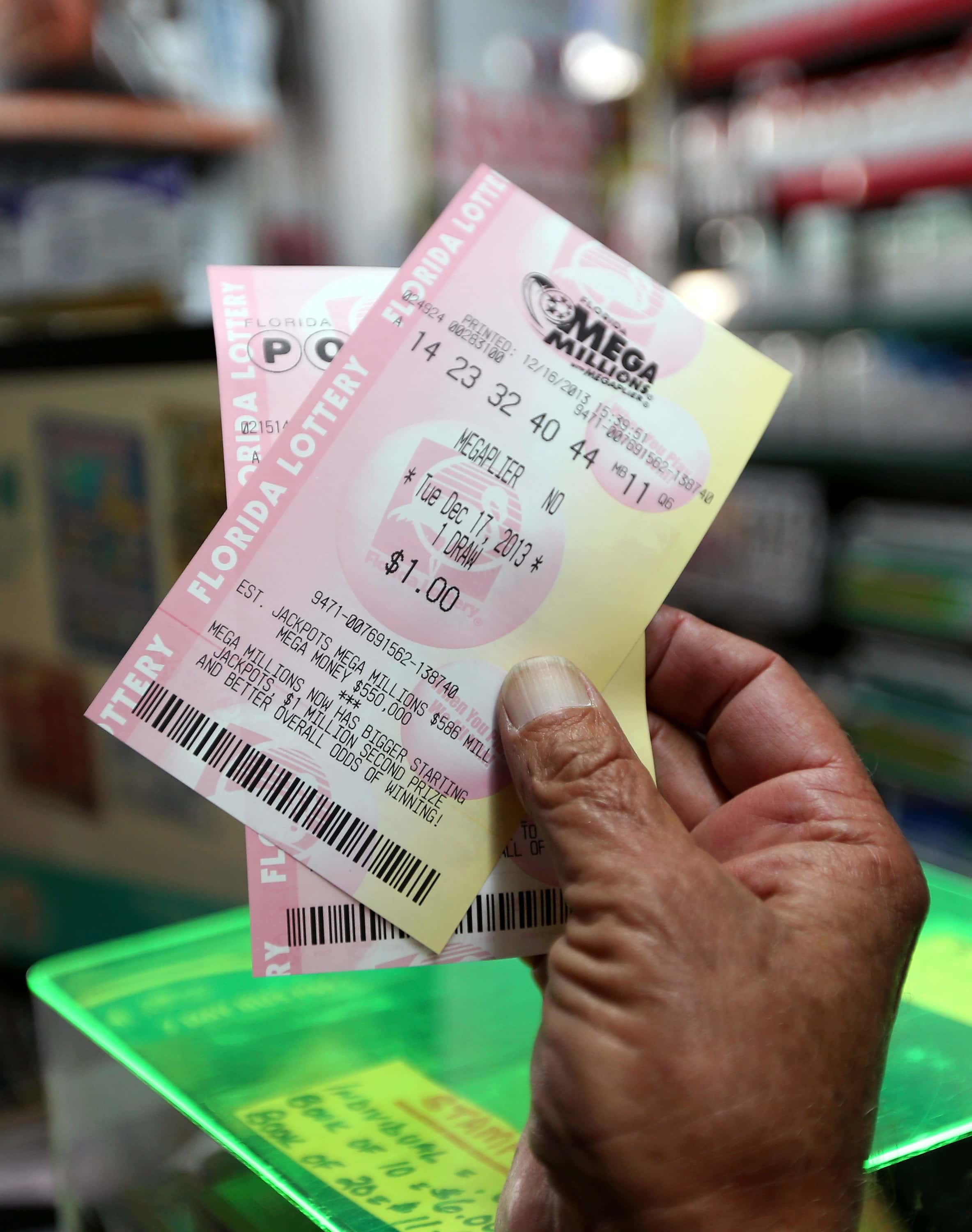HOLLYWOOD, FL - DECEMBER 16: Richard Mcenery purchases Mega Million lottery tickets at Circle News Stand on December 16, 2013 in Hollywood, Florida. The Mega Millions lottery jackpot has reached $586 million, and that total could increase again before Tuesday night's drawing. (Photo by Joe Raedle/Getty Images)