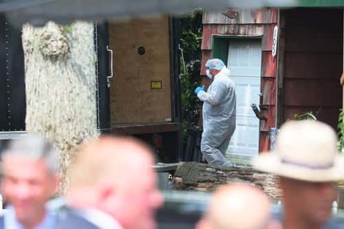 Law enforcement officials are seen as they investigate the home of a suspect arrested in the unsolved Gilgo Beach killings on July 14, 2023 in Massapequa Park, New York. A suspect in the Gilgo Beach killings was arrested in the unsolved case tied to at least 10 sets of human remains that were discovered since 2010 in suburban Long Island. The suspect Rex Heuermann is expected to be arraigned after his arrest Thursday night. A grand jury charged Heurmann with six counts of murder. The charges stem from the deaths of three of the four 
