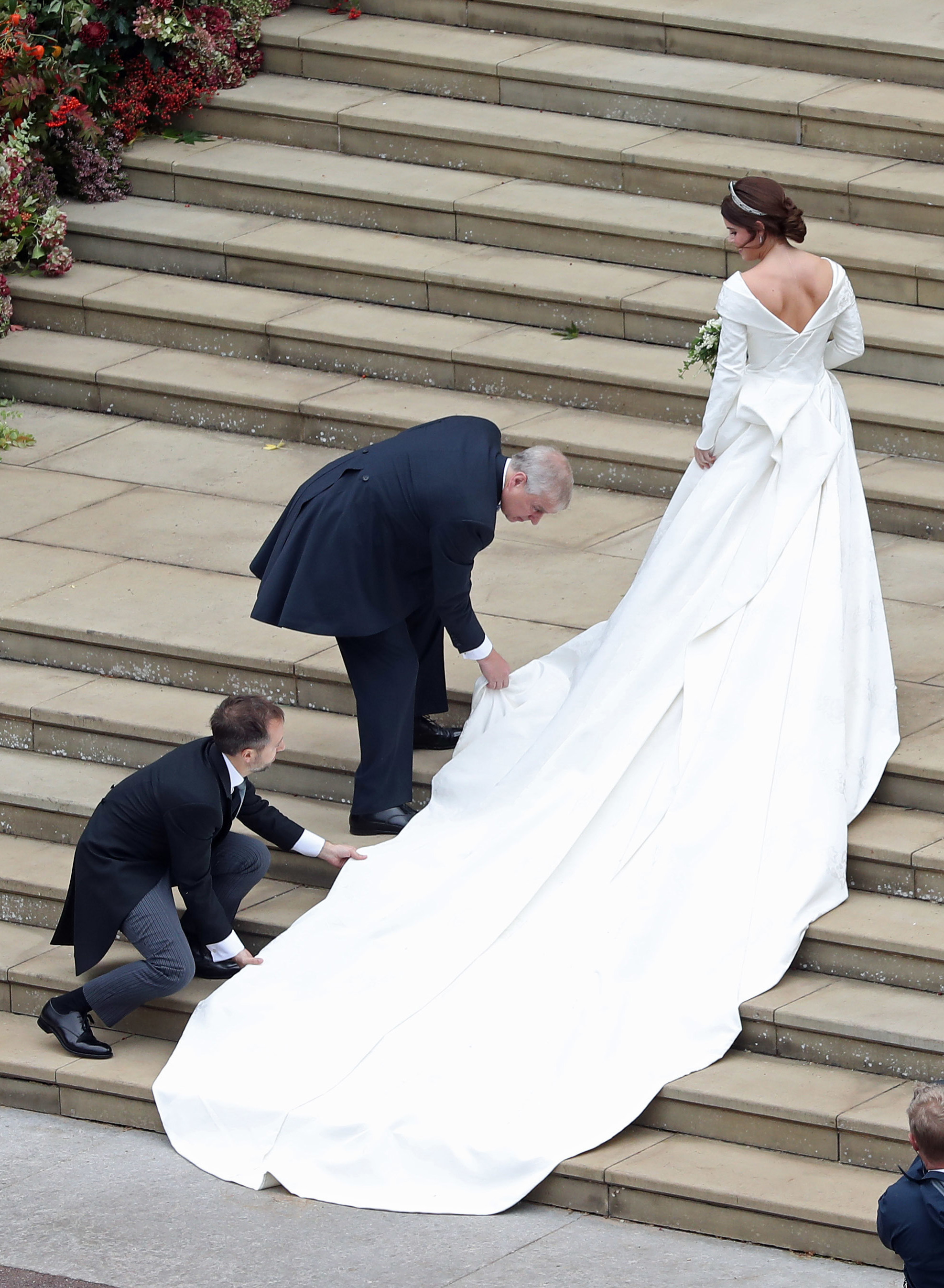 Princess Eugenie of York receives help with her train from her father Prince Andrew, Duke of York as she arrives to her wedding to Mr. Jack Brooksbank at St. George's Chapel on October 12, 2018 in Windsor, England.