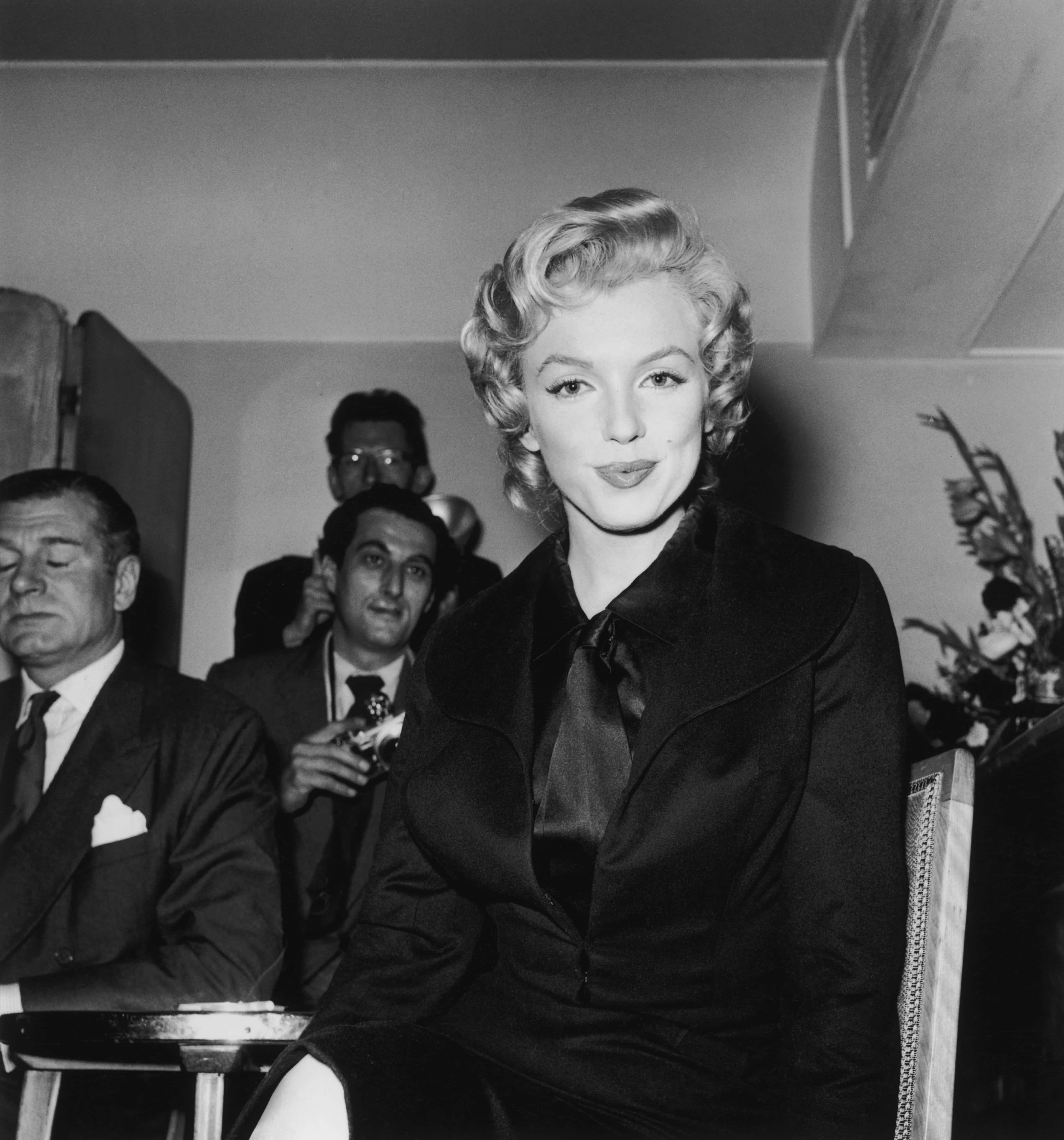 American film star Marilyn Monroe (1926 - 1962) at a press conference at the Savoy Hotel, London, 17th July 1956.  On the left is her co-star in the film 'The Prince and the Showgirl', Laurence Olivier (1907 - 1989). (Photo by Harry Kerr/BIPS/Hulton Archive/Getty Images)