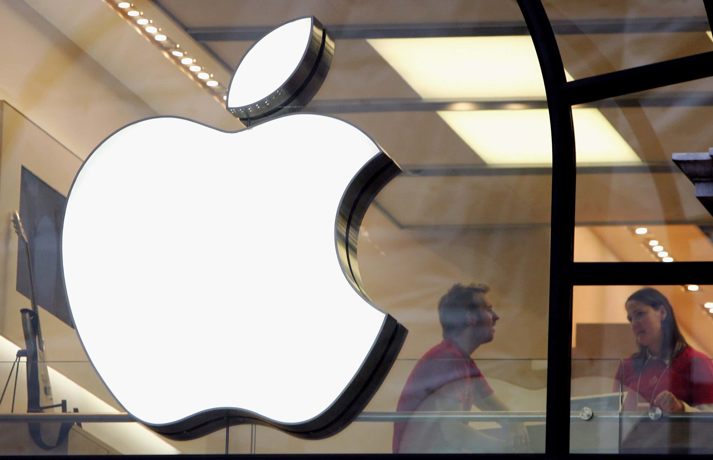LONDON - DECEMBER 27:  People are seen behind the Apple logo in Apple's flagship London retail store