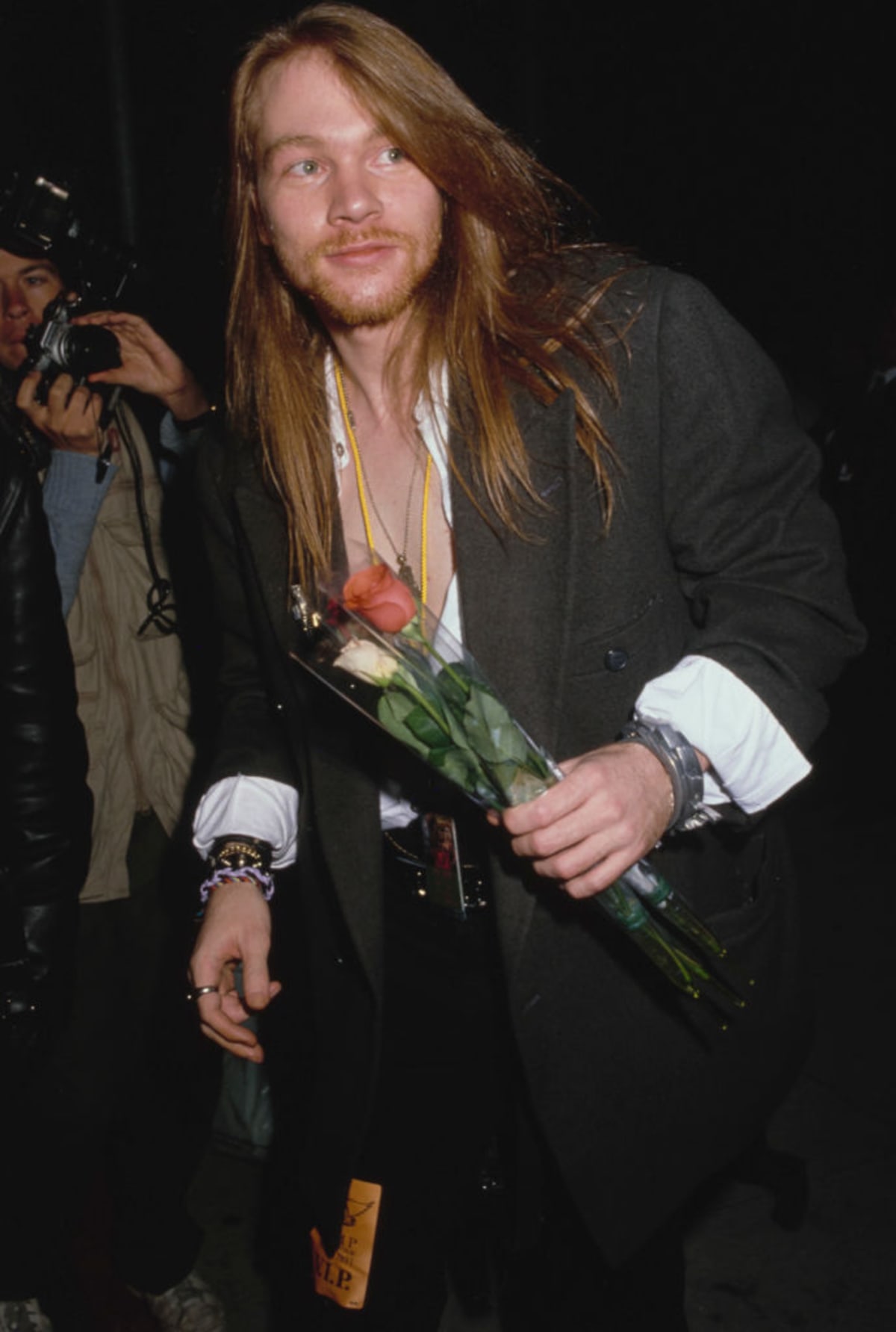 American singer and songwriter Axl Rose, wearing a black suit jacket with the cuffs folded back, holding a small bunch of flowers, in Los Angeles, California, circa 1990. (Photo by Vinnie Zuffante/Michael Ochs Archives/Getty Images)