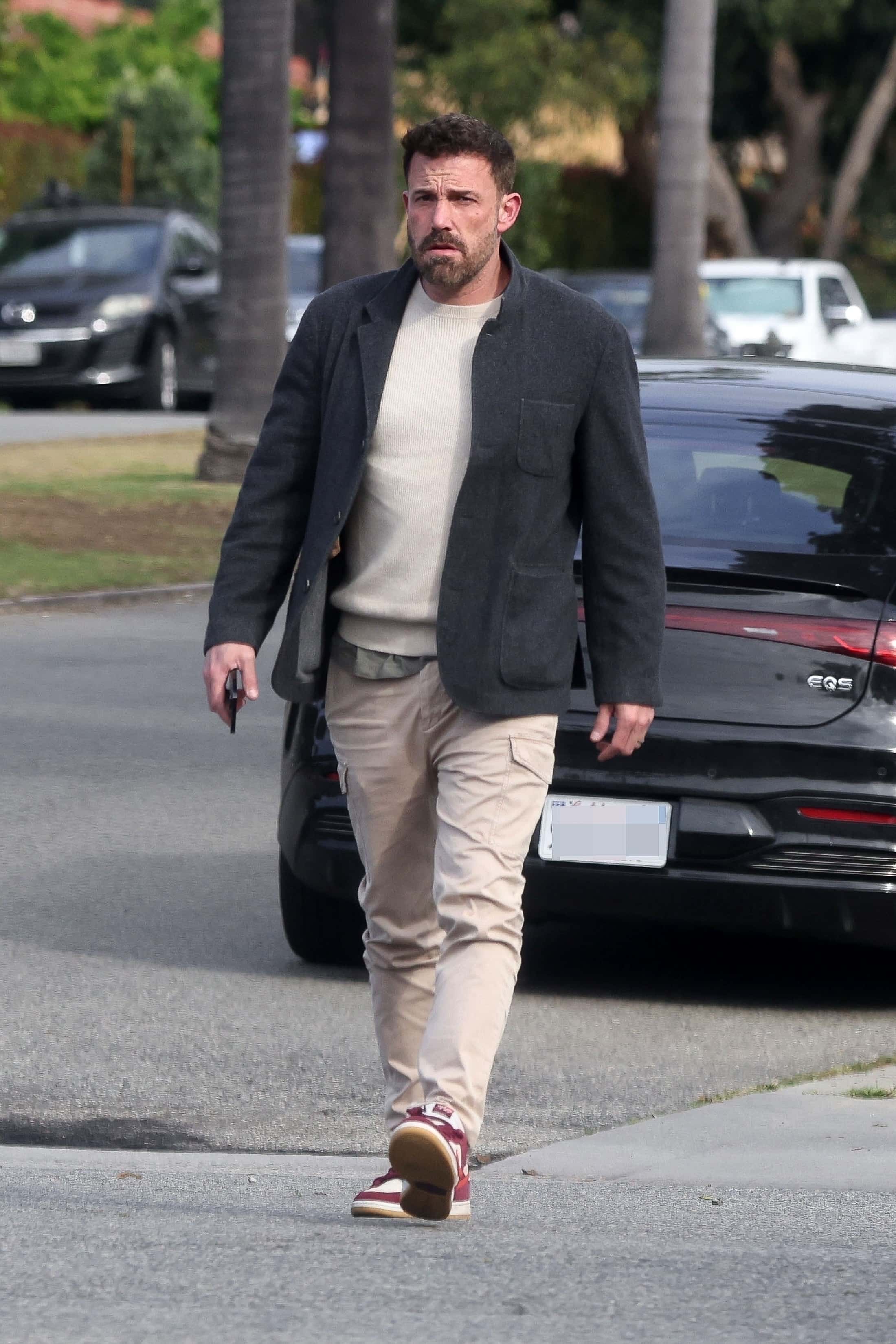 Ben Affleck looked ready for his work day in a pair of tan cargo pants, a gray jacket and red, burgundy and red sneakers (Backgrid)