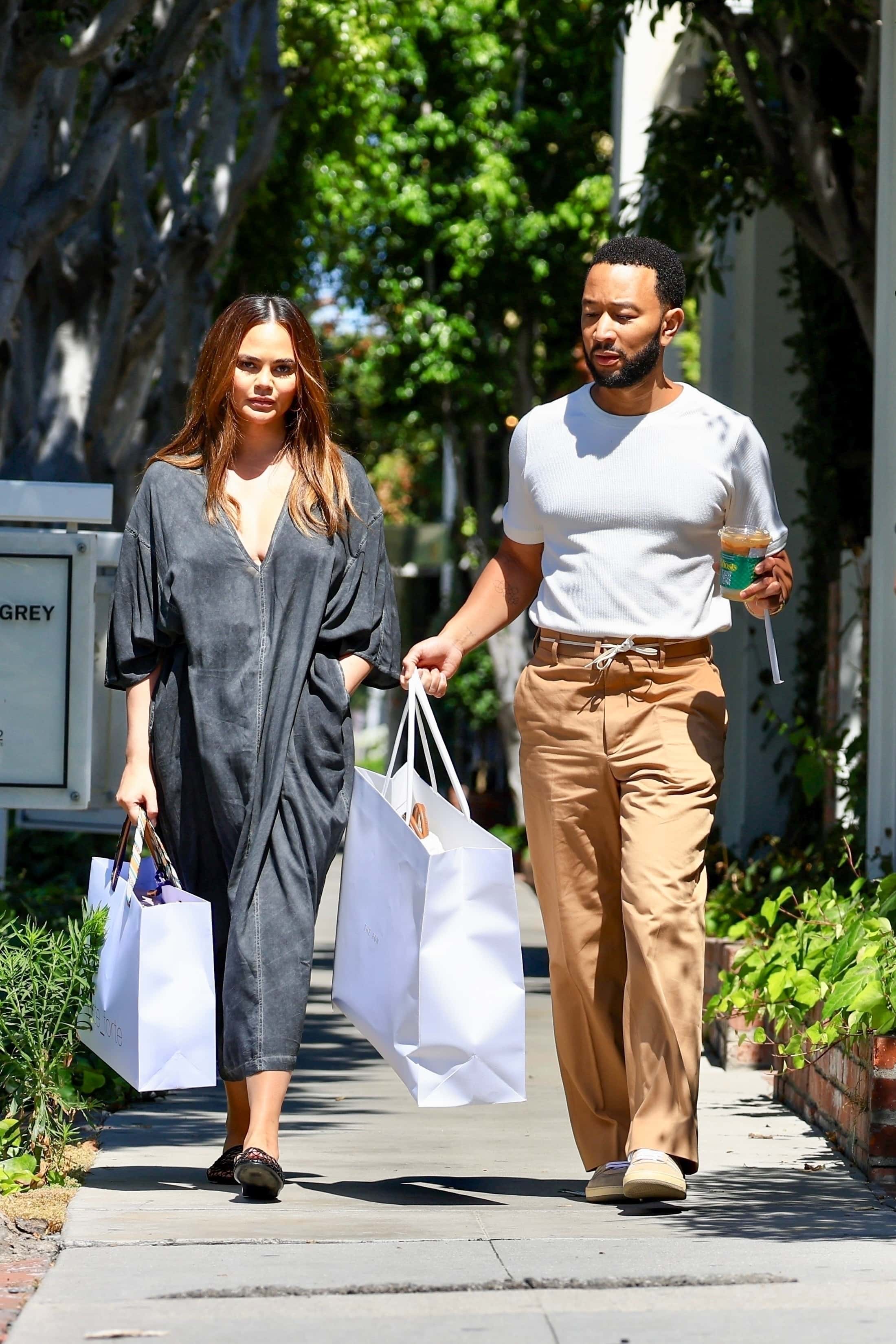 As they strolled together, the couple engaged in conversation while John Legend skillfully balanced a delicious iced coffee in his left hand, adding a touch of energy and refreshment to their outing (Backgrid)