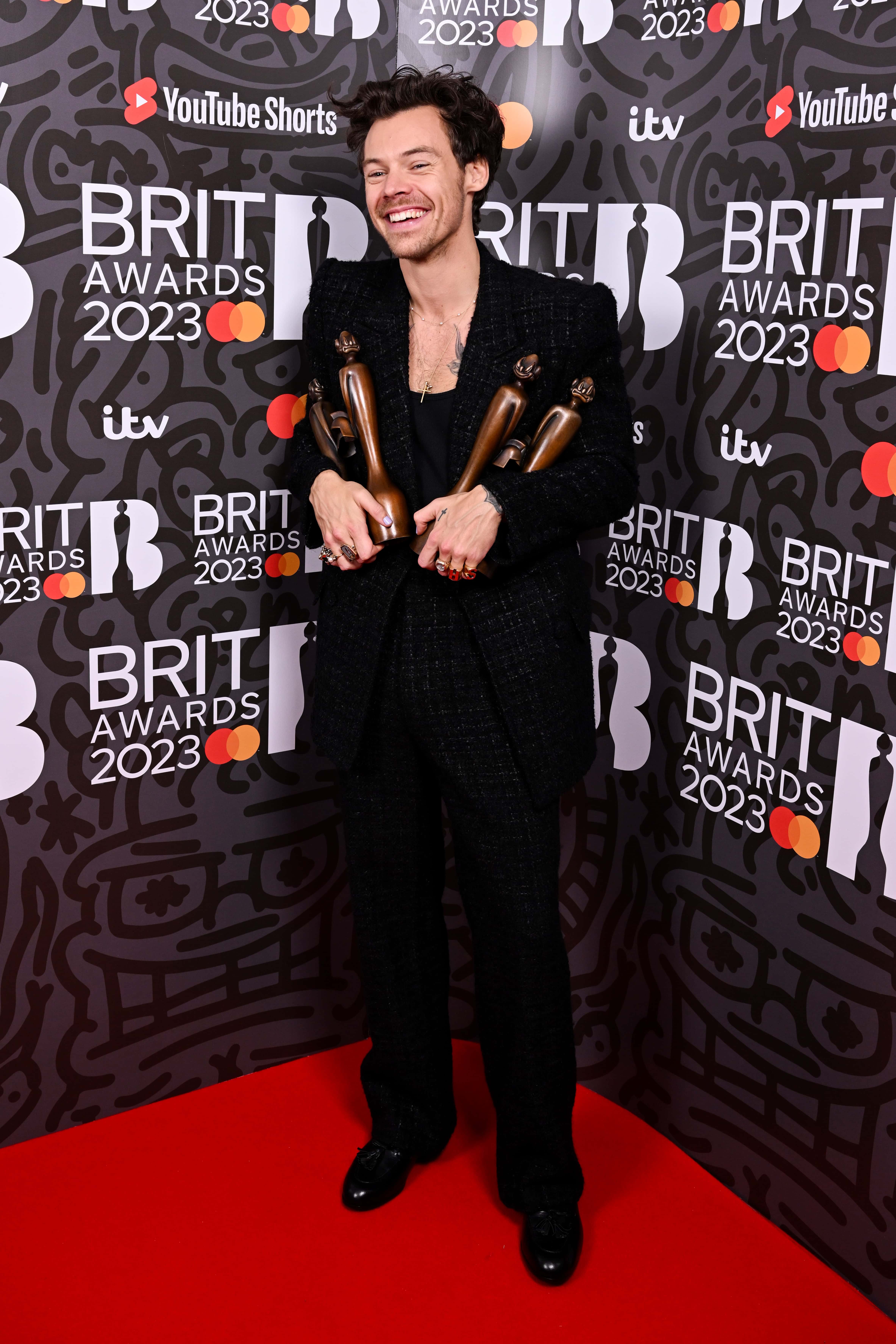 Harry Styles poses with the awards for British Pop/R&B Act, British Artist of the Year, Song of the Year and Album of the Year in the media room during The BRIT Awards 2023 at The O2 Arena on February 11, 2023, in London, England. (Photo by Jeff Spicer/Getty Images)