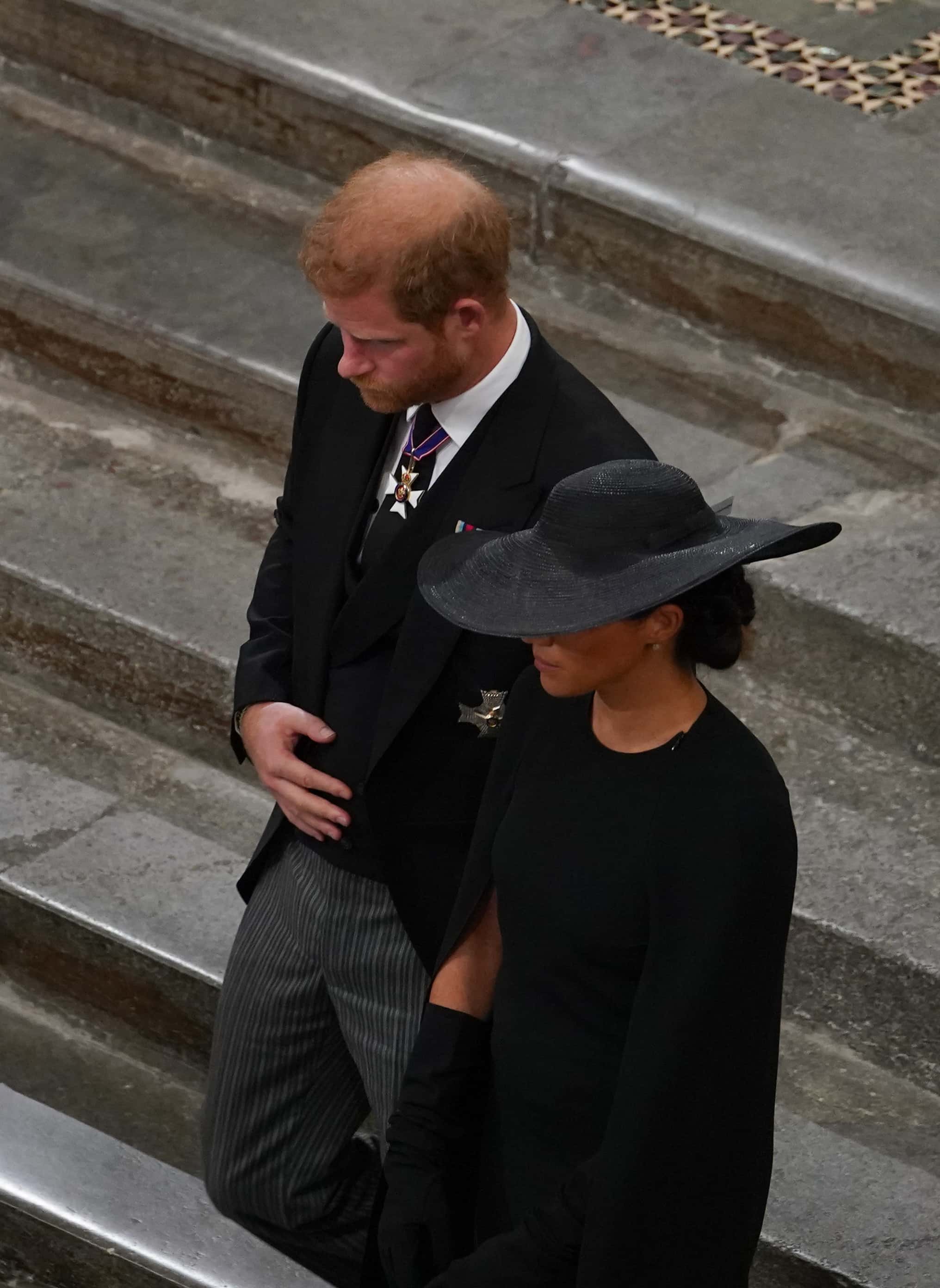 Prince Harry, Duke of Sussex and Meghan, Duchess of Sussex follow the bearer party with the coffin of Queen Elizabeth II as it leaves Westminster Abbey for Wellington Arch, during the State Funeral of Queen Elizabeth II at Westminster Abbey on September 19, 2022 in London, England.  Elizabeth Alexandra Mary Windsor was born in Bruton Street, Mayfair, London on 21 April 1926. She married Prince Philip in 1947 and ascended the throne of the United Kingdom and Commonwealth on 6 February 1952 after the death of her Father, King George VI. Queen Elizabeth II died at Balmoral Castle in Scotland on September 8, 2022, and is succeeded by her eldest son, King Charles III.