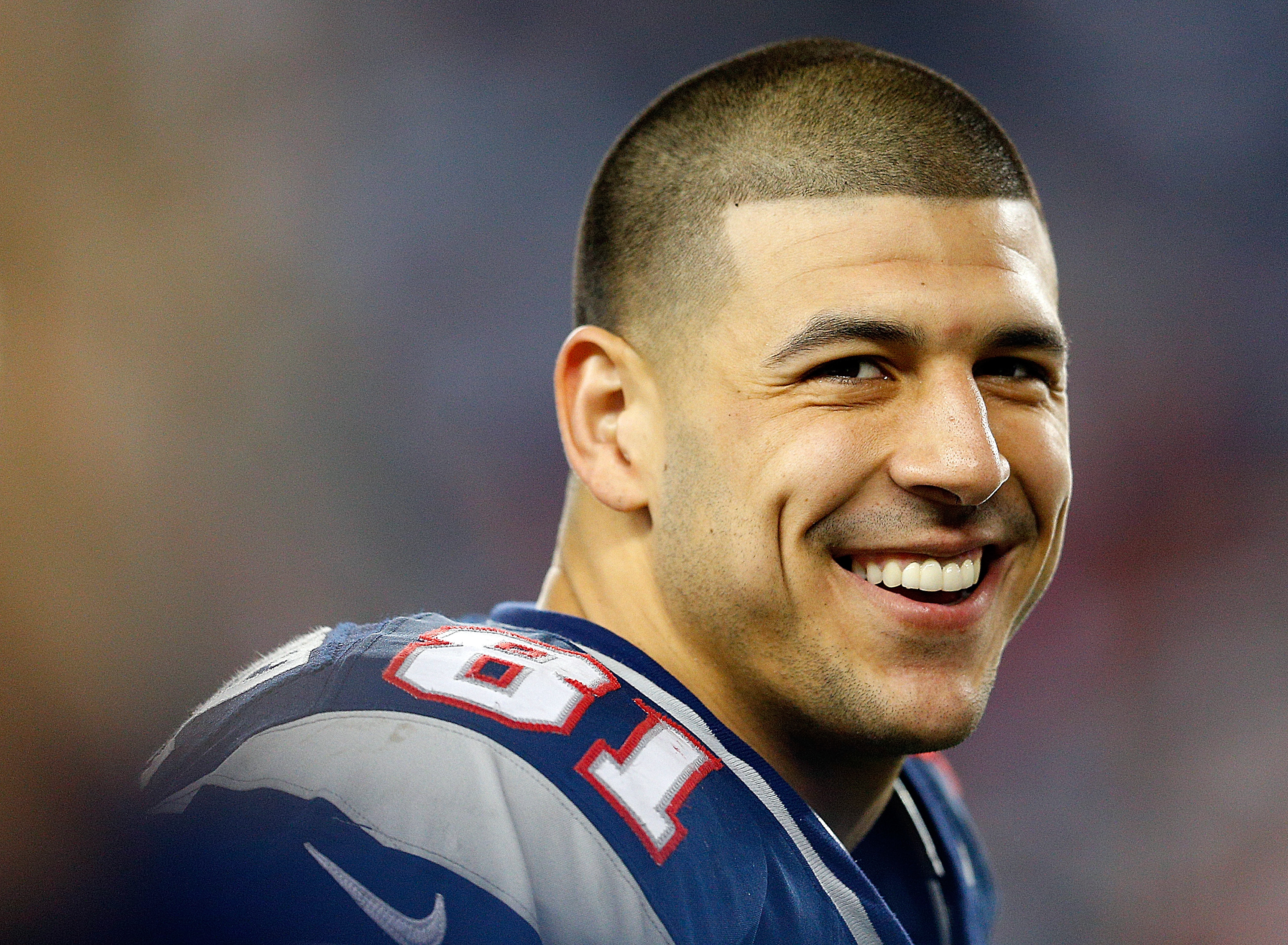 Aaron Hernandez #81 of the New England Patriots smiles from the sidelines in the fourth quarter during a game against the Houston Texans at Gillette Stadium on December 10, 2012 in Foxboro, Massachusetts.