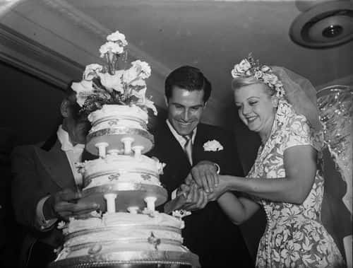 British actress Angela Lansbury and her husband, Peter Shaw, cutting the cake at their wedding.