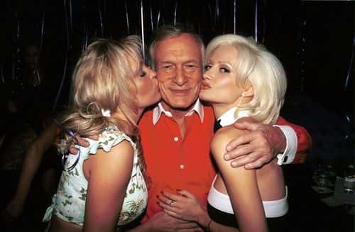 Playboy publisher Hugh Hefner (C) gets kisses from Playboy playmates Bridget and Holly Madison (R) at Hefner's 77th birthday party at Barfly March 30, 2003 in West Hollywood, California.