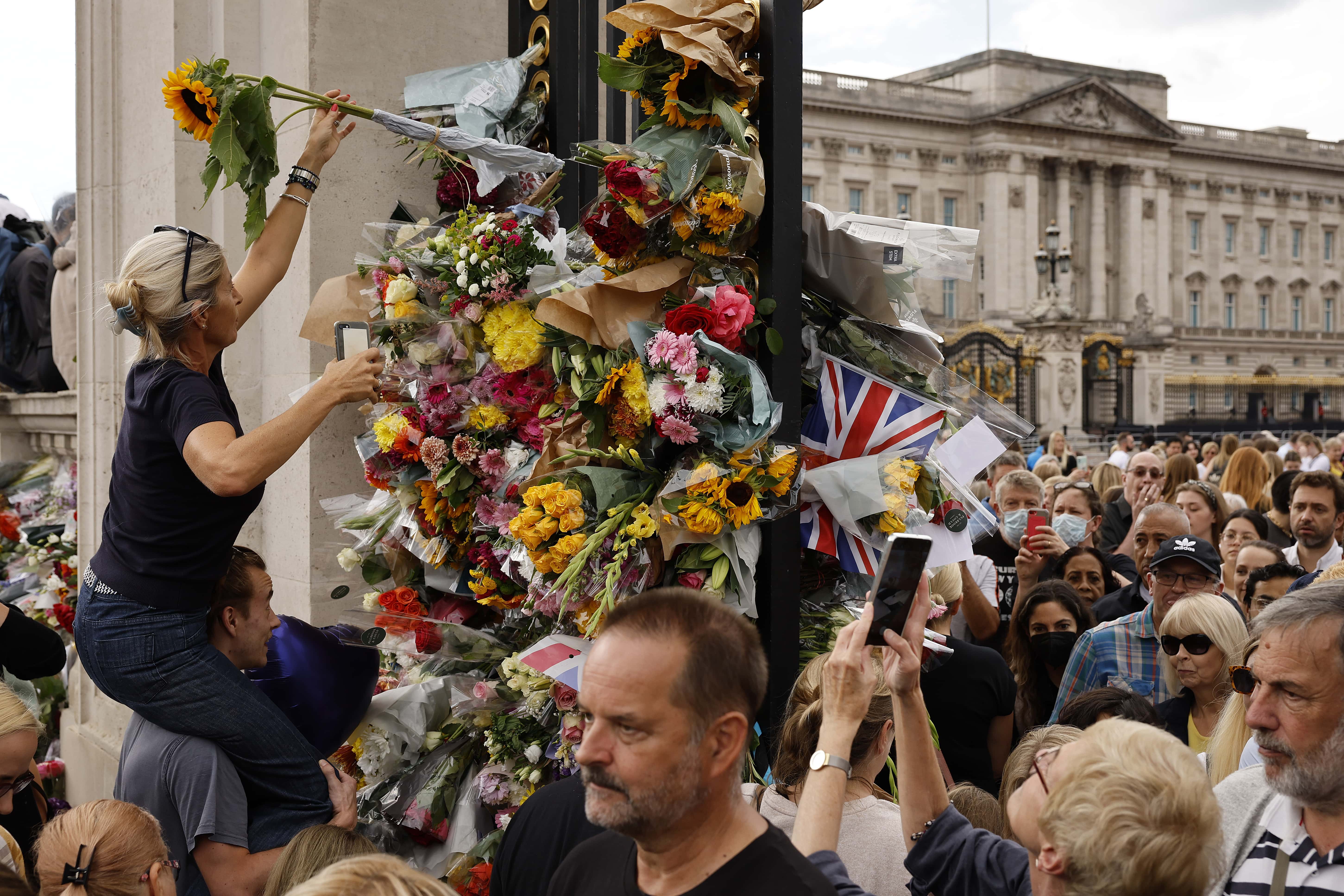 People pay their respect by placing flowers into the ironwork of a gate outside of Buckingham Palace following the death of Queen Elizabeth II on September 10, 2022 in London, United Kingdom. Elizabeth Alexandra Mary Windsor was born in Bruton Street, Mayfair, London on 21 April 1926. She married Prince Philip in 1947 and acceded to the throne of the United Kingdom and Commonwealth on 6 February 1952 after the death of her Father, King George VI. Queen Elizabeth II died at Balmoral Castle in Scotland on September 8, 2022, and is succeeded by her eldest son, King Charles III.
