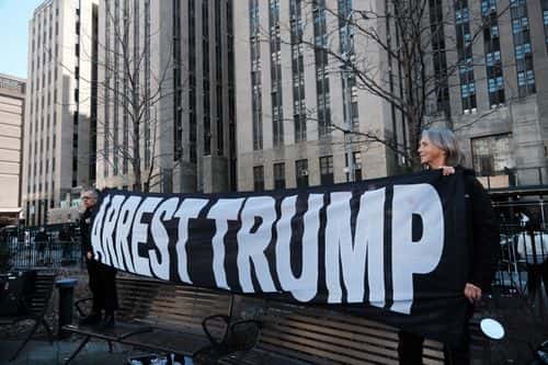 People gather outside of a Manhattan courthouse as the nation waits for the possibility of an indictment against former president Donald Trump by the Manhattan District Attorney Alvin Bragg's office on March 21, 2023 in New York City. NYC and other cities are bracing for a possible indictment of former President Donald Trump by Manhattan District Attorney Alvin Bragg in his investigation into the former president's involvement in a hush money payment to adult film actress Stormy Daniels before the 2016 presidential election.