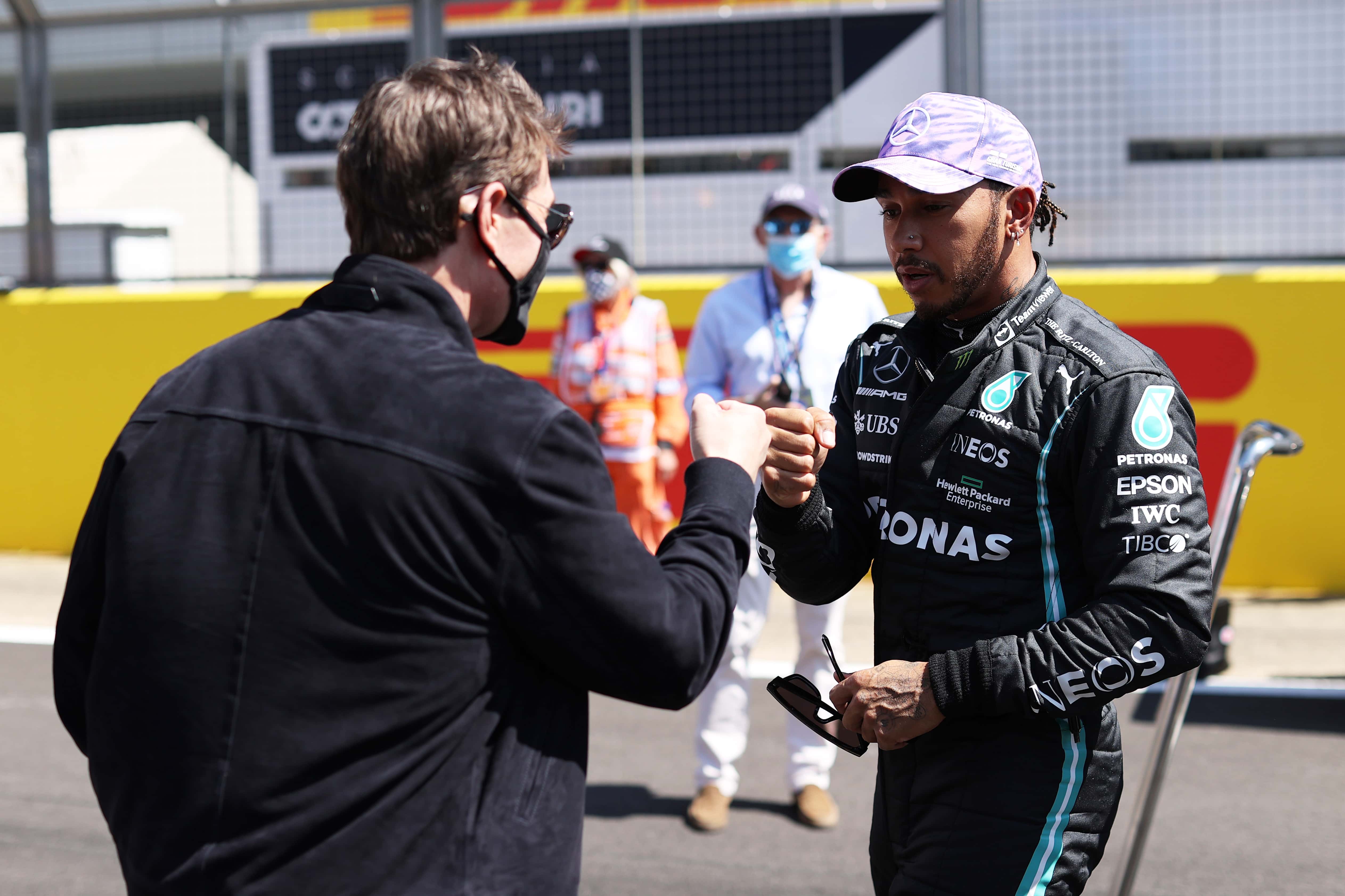 Tom Cruise bumps fists with Lewis Hamilton of Great Britain and Mercedes GP on the grid before the F1 Grand Prix of Great Britain at Silverstone on July 18, 2021 in Northampton, England.