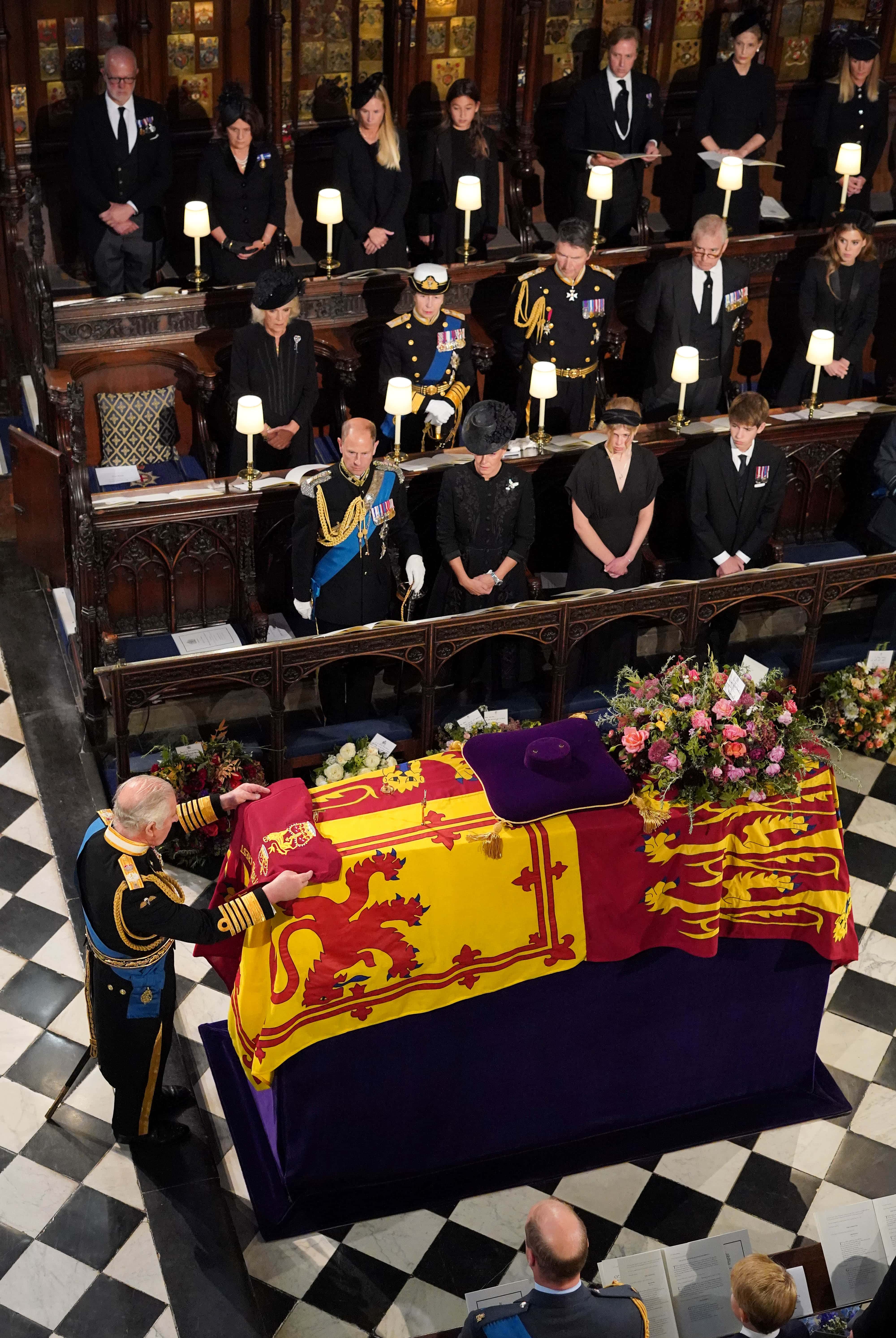 King Charles III places the the Queen's Company Camp Colour of the Grenadier Guards on the coffin of Queen Elizabeth II during the Committal Service for Queen Elizabeth II at St George's Chapel, Windsor Castle on September 19, 2022 in Windsor, England. The committal service at St George's Chapel, Windsor Castle, took place following the state funeral at Westminster Abbey. A private burial in The King George VI Memorial Chapel followed. Queen Elizabeth II died at Balmoral Castle in Scotland on September 8, 2022, and is succeeded by her eldest son, King Charles III.