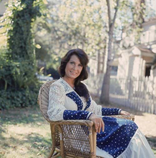 Portrait of American country music singer and guitarist Loretta Lynn as she sits outside in a chair, 1970s. (Photo by Hulton Archive/Getty Images)