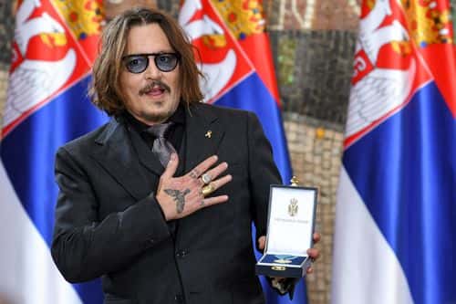 Actor Johnny Depp gestures as he receives the Gold Medal of Merit, on the occasion of Serbia's Statehood Day, on February 15, 2022 in Belgrade, Serbia.