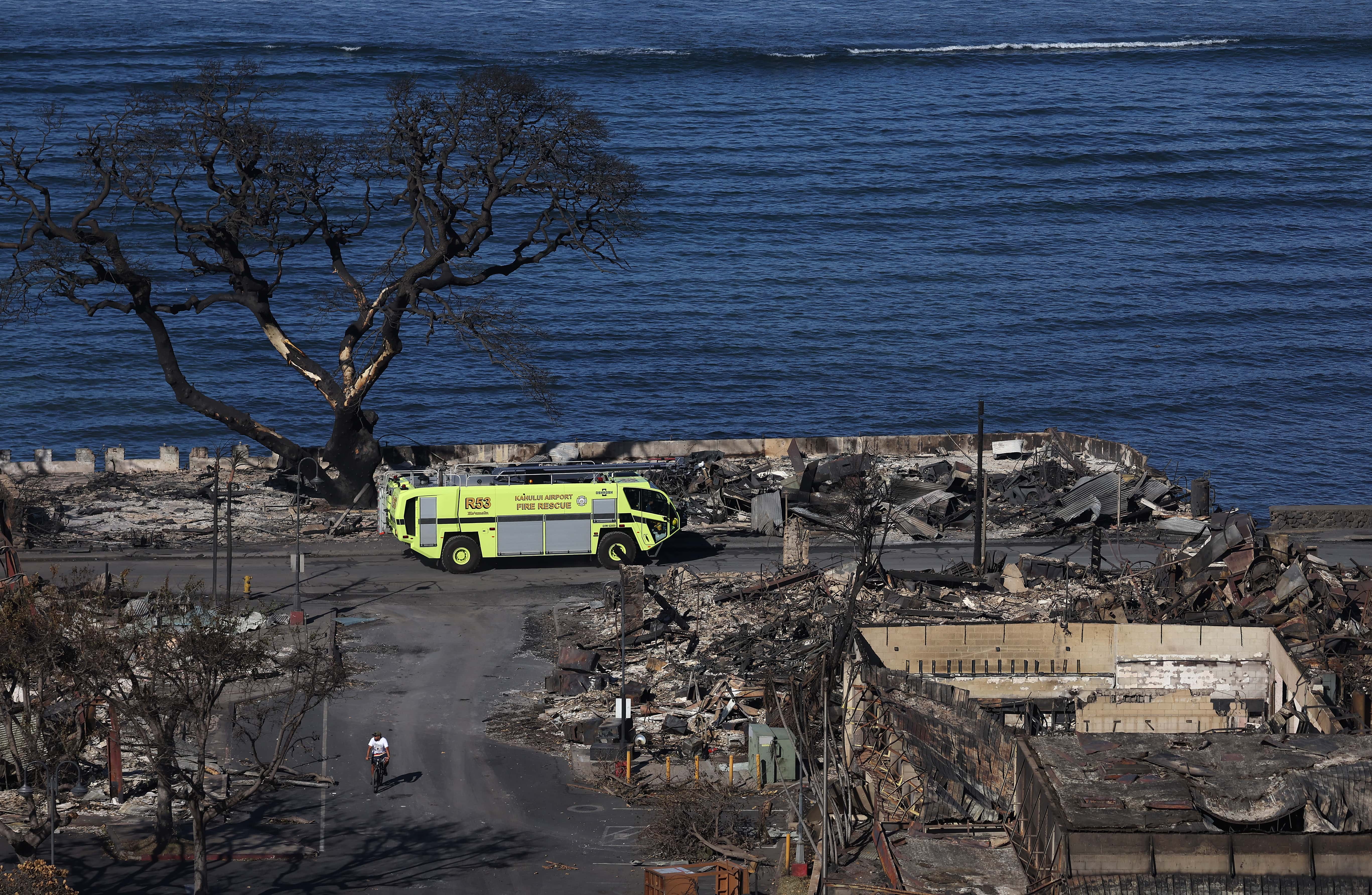 In an aerial view, a fire truck drives through a neighborhood destroyed by a wildfire on August 11, 2023 in Lahaina, Hawaii. Dozens of people were killed and thousands were displaced after a wind-driven wildfire devastated the town of Lahaina on Tuesday. Crews are continuing to search for missing people.