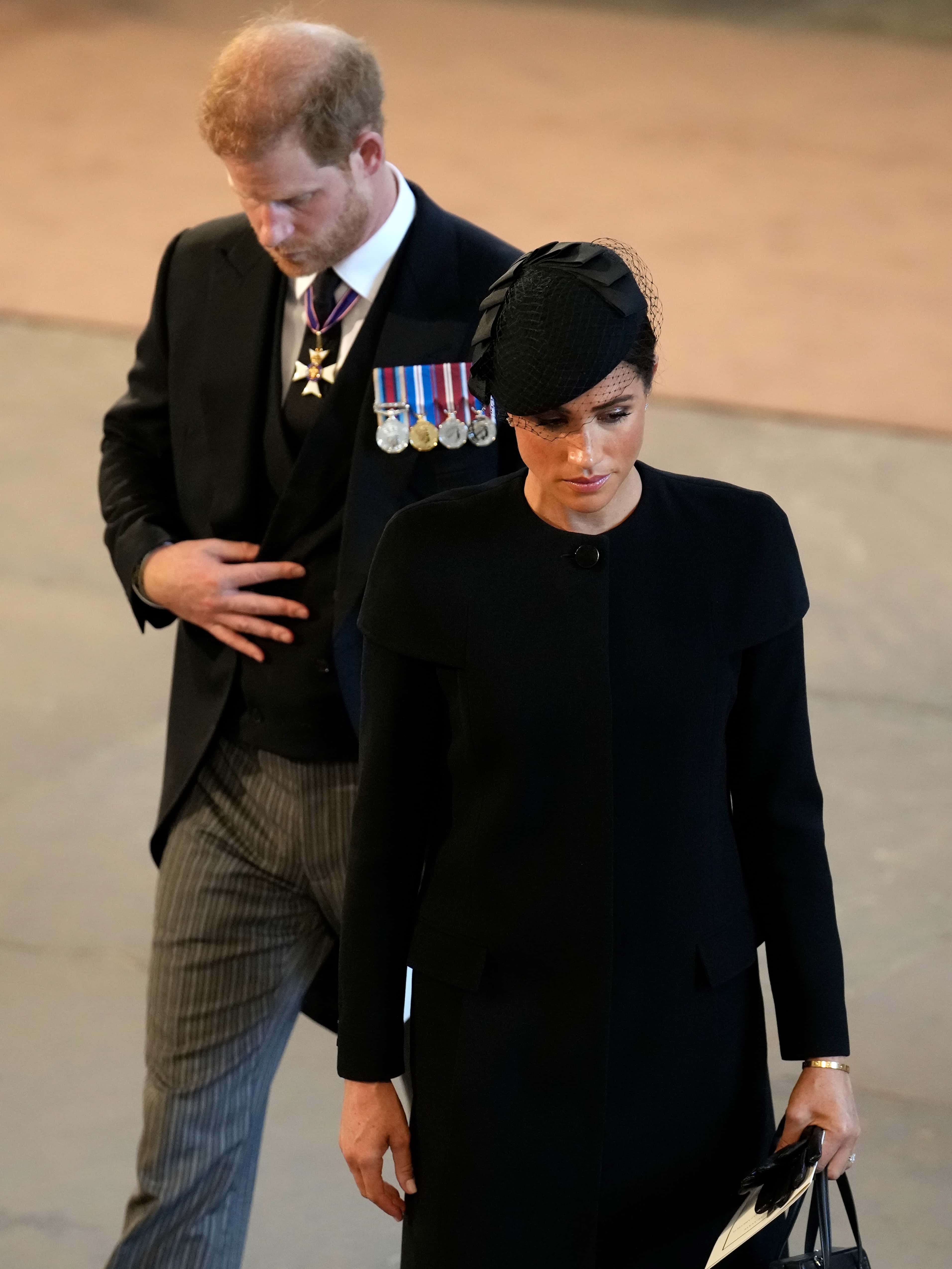 Prince Harry, Duke of Sussex and Meghan, Duchess of Sussex pay their respects at The Palace of Westminster during the procession for the Lying-in State of Queen Elizabeth II on September 14, 2022 in London, England. Queen Elizabeth II's coffin is taken in procession on a Gun Carriage of The King's Troop Royal Horse Artillery from Buckingham Palace to Westminster Hall where she will lay in state until the early morning of her funeral. Queen Elizabeth II died at Balmoral Castle in Scotland on September 8, 2022, and is succeeded by her eldest son, King Charles III.