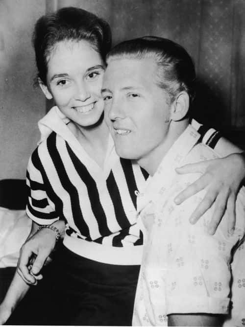 American rock musician Jerry Lee Lewis holds his second cousin and third wife Myra Brown in his lap at a press conference in the Westbury Hotel, London, May 23, 1958. (Photo by Hulton Archive/Getty Images)