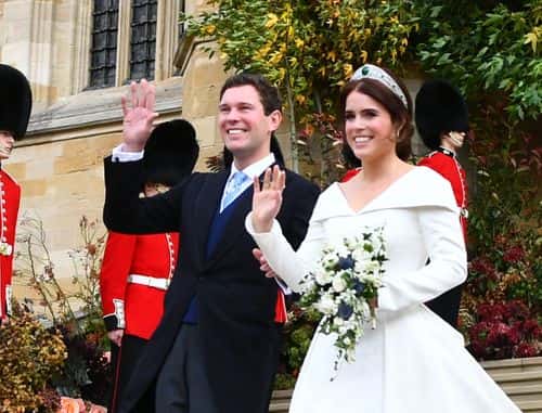 Princess Eugenie of York and husband Jack Brooksbank wave as they walk down the West Steps as they leave St George's Chapel in Windsor Castle following their wedding on October 12, 2018 in Windsor, England.
