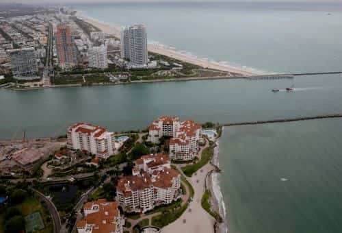The coast line of Miami Beach and part of Fisher Island (bottom) are seen June 3, 2014 in Miami, Florida. According to numerous scientists, south Florida could be flooded by the end of the century as global warming continues to melt the Arctic ice, in turn causing oceans to rise. U.S. President Barack Obama and the Environmental Protection Agency yesterday announced a rule that would reduce the nation's biggest source of pollution, carbon emissions from power plants, 30% by 2030 compared to 2005 levels.  It is widely believed that these emissions are a main cause of global warming.