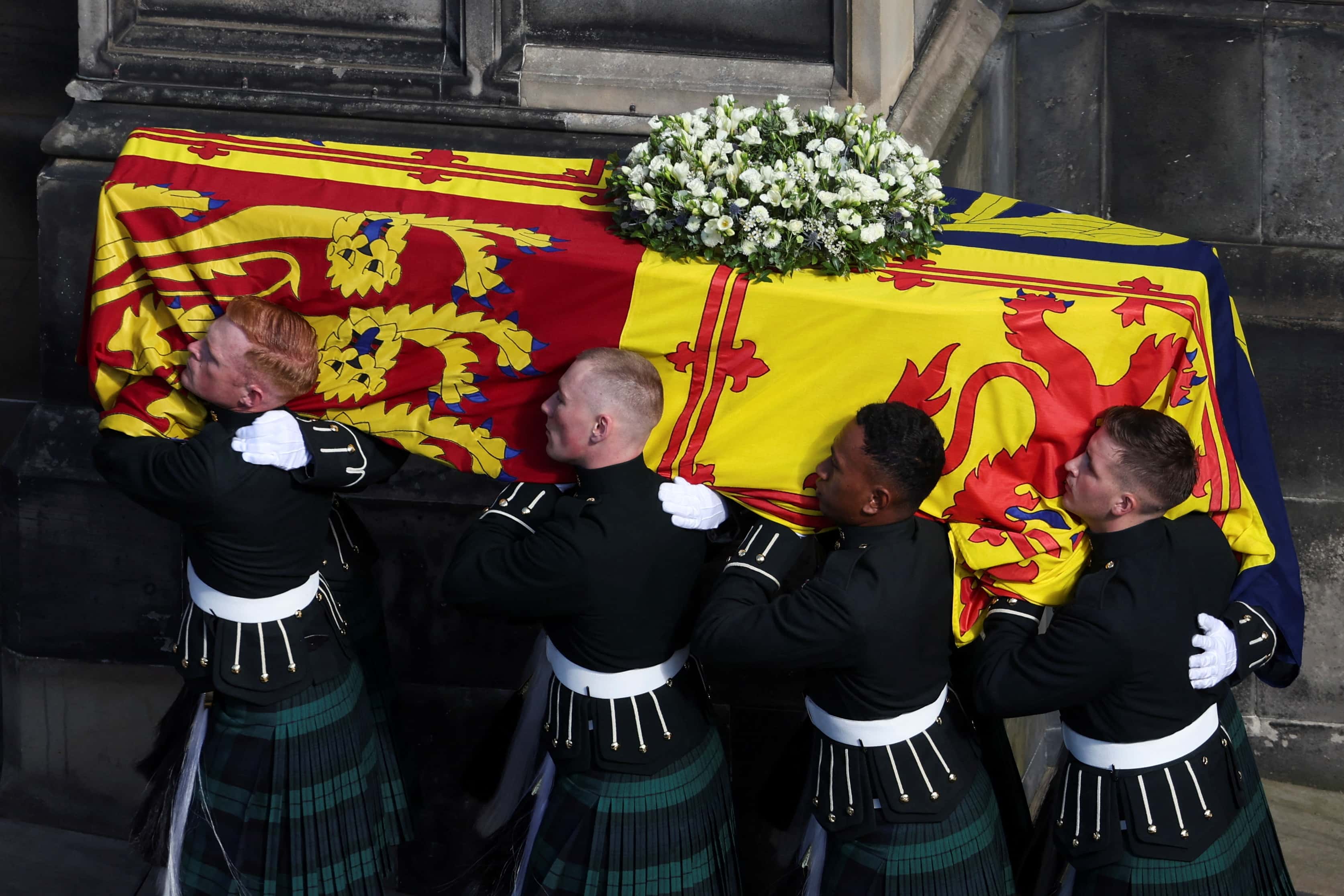 Pallbearers carry the coffin of Britain's Queen Elizabeth II as the hearse arrives at St. Giles' Cathedral after the procession from the Palace of Holyroodhouse on September 12, 2022 in Edinburgh, Scotland. King Charles III joins the procession accompanying Her Majesty The Queen's coffin from the Palace of Holyroodhouse along the Royal Mile to St Giles Cathedral. The King and The Queen Consort, accompanied by other Members of the Royal Family also attend a Service of Prayer and Reflection for the Life of The Queen where it lies in rest for 24 hours before being transferred by air to London.