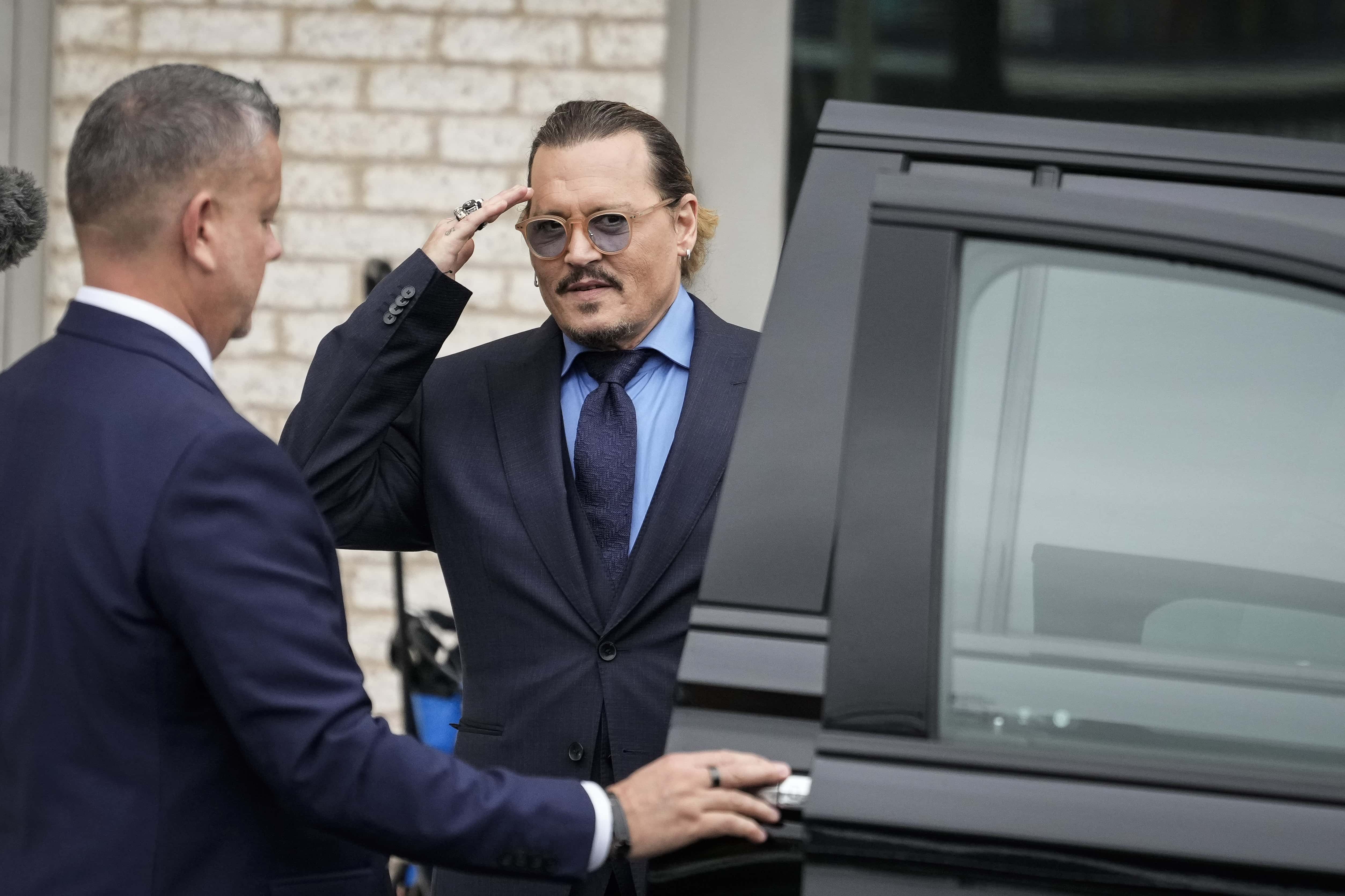 Actor Johnny Depp salutes toward fans as he departs the Fairfax County Courthouse on May 27, 2022 in Fairfax, Virginia.&nbsp;Closing arguments in the Depp v. Heard defamation trial, brought by Johnny Depp against his ex-wife Amber Heard, concluded today and jury deliberations begin.