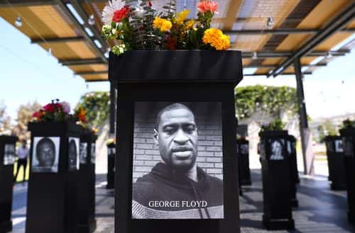 A photograph of George Floyd (C) is displayed along with other photographs at the Say Their Names memorial exhibit at Martin Luther King Jr. Promenade on July 20, 2021 in San Diego, California. The traveling memorial features photographs of 200 Black Americans who lost their lives due to systemic racism and racial injustice and is sponsored by the San Diego African American Museum of Fine Art (SDAAMFA). Former Minneapolis police officer Derek Chauvin was sentenced to 22 years and six months in prison after being convicted of murder in the death of George Floyd. (Photo by Mario Tama/Getty Images)