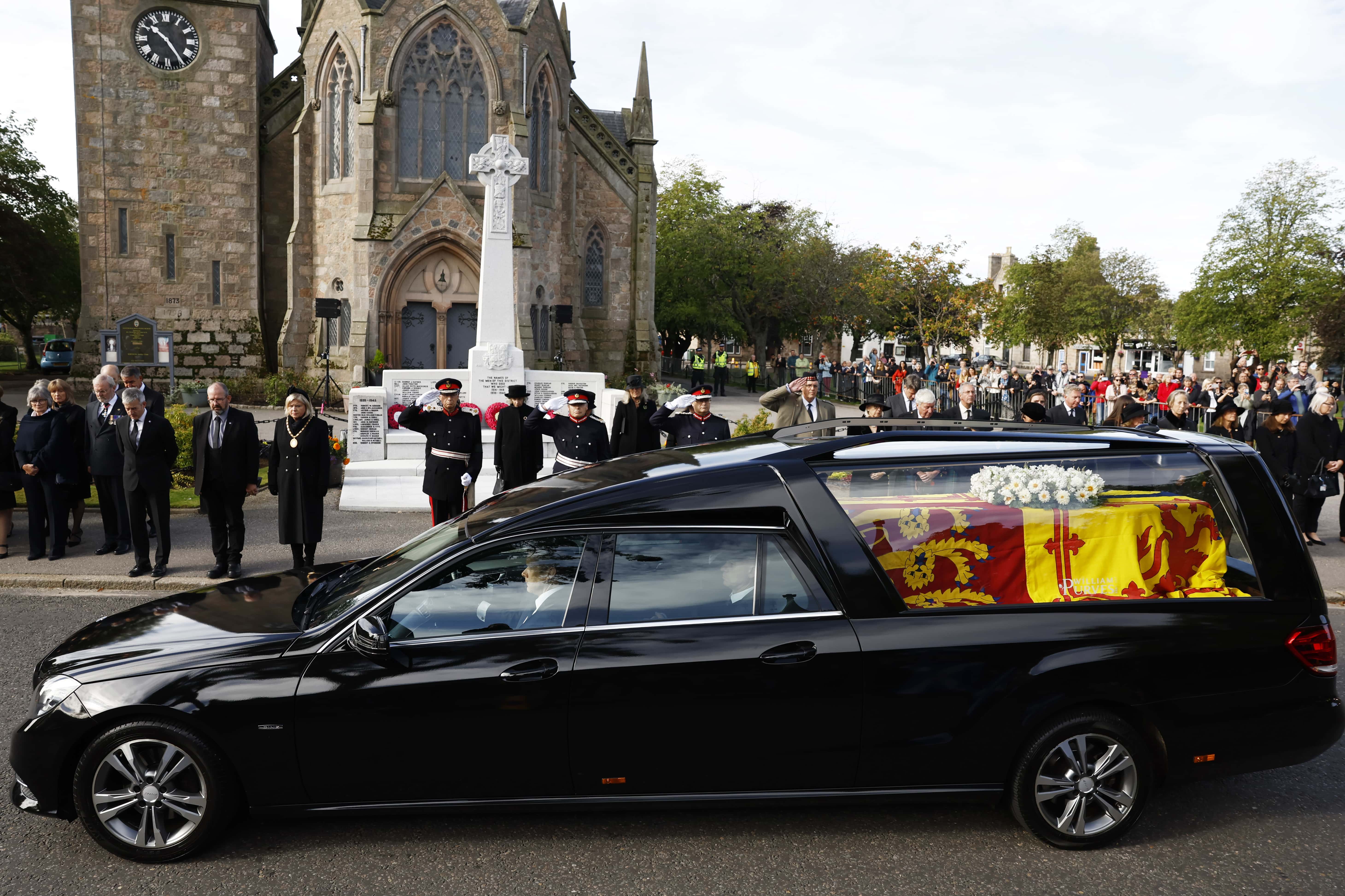People gather in tribute as the cortege carrying the coffin of the late Queen Elizabeth II passes by on September 11, 2022 in Ballater, United Kingdom. Elizabeth Alexandra Mary Windsor was born in Bruton Street, Mayfair, London on 21 April 1926. She married Prince Philip in 1947 and ascended the throne of the United Kingdom and Commonwealth on 6 February 1952 after the death of her Father, King George VI. Queen Elizabeth II died at Balmoral Castle in Scotland on September 8, 2022, and is succeeded by her eldest son, King Charles III.